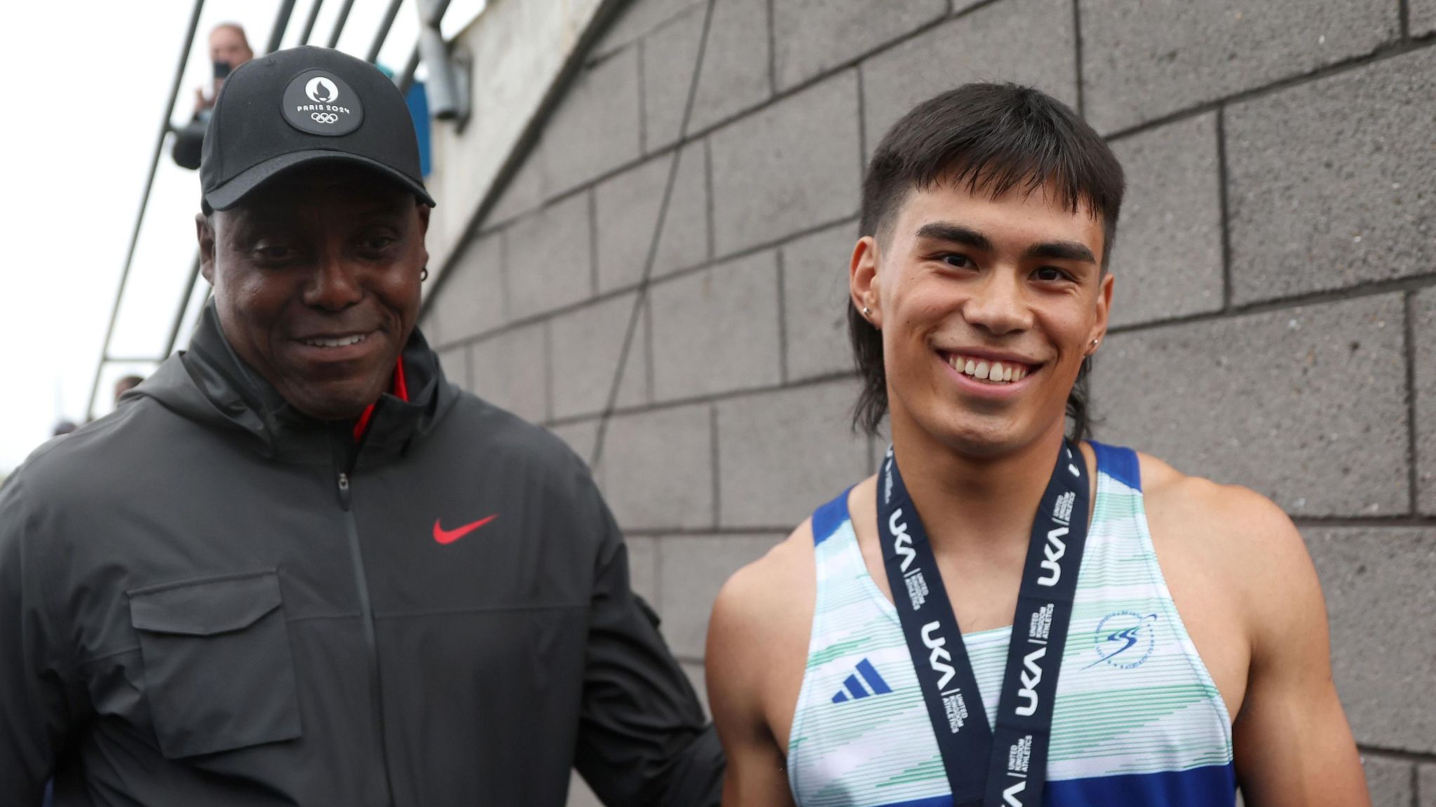 Louie Hinchliffe celebrates qualifying for Paris 2024 with coach Carl Lewis