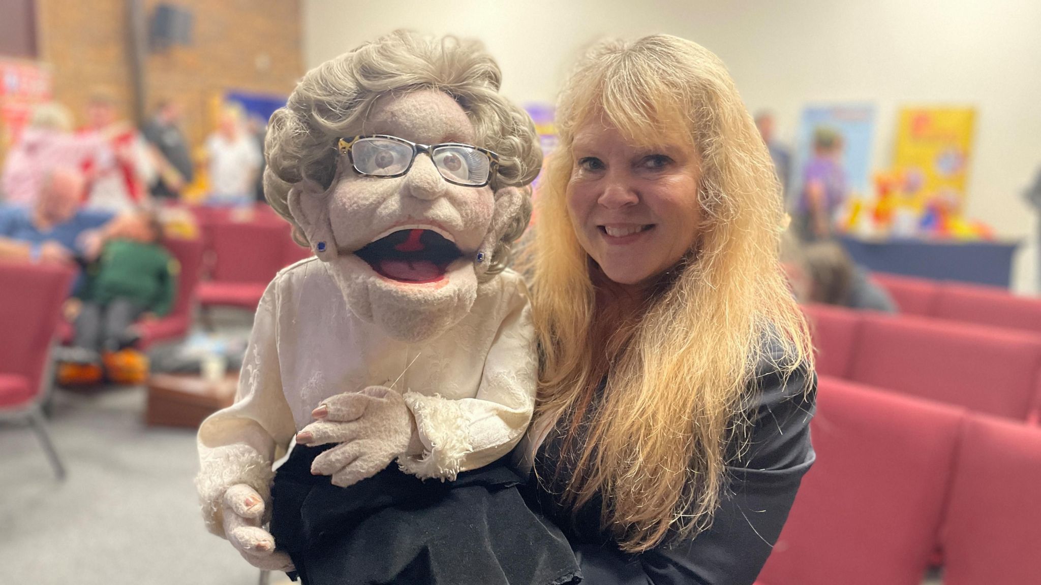 Trish Dunn smiling with her puppet Agnes