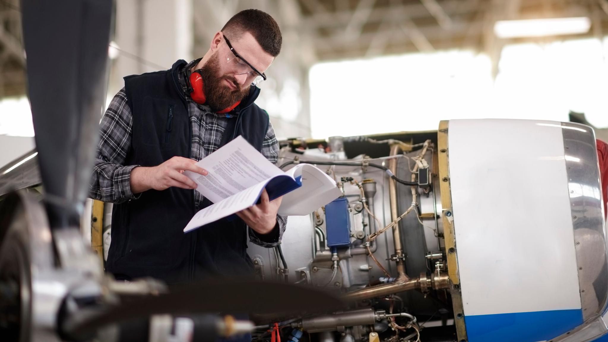 An aerospace engineer reading an instruction manual