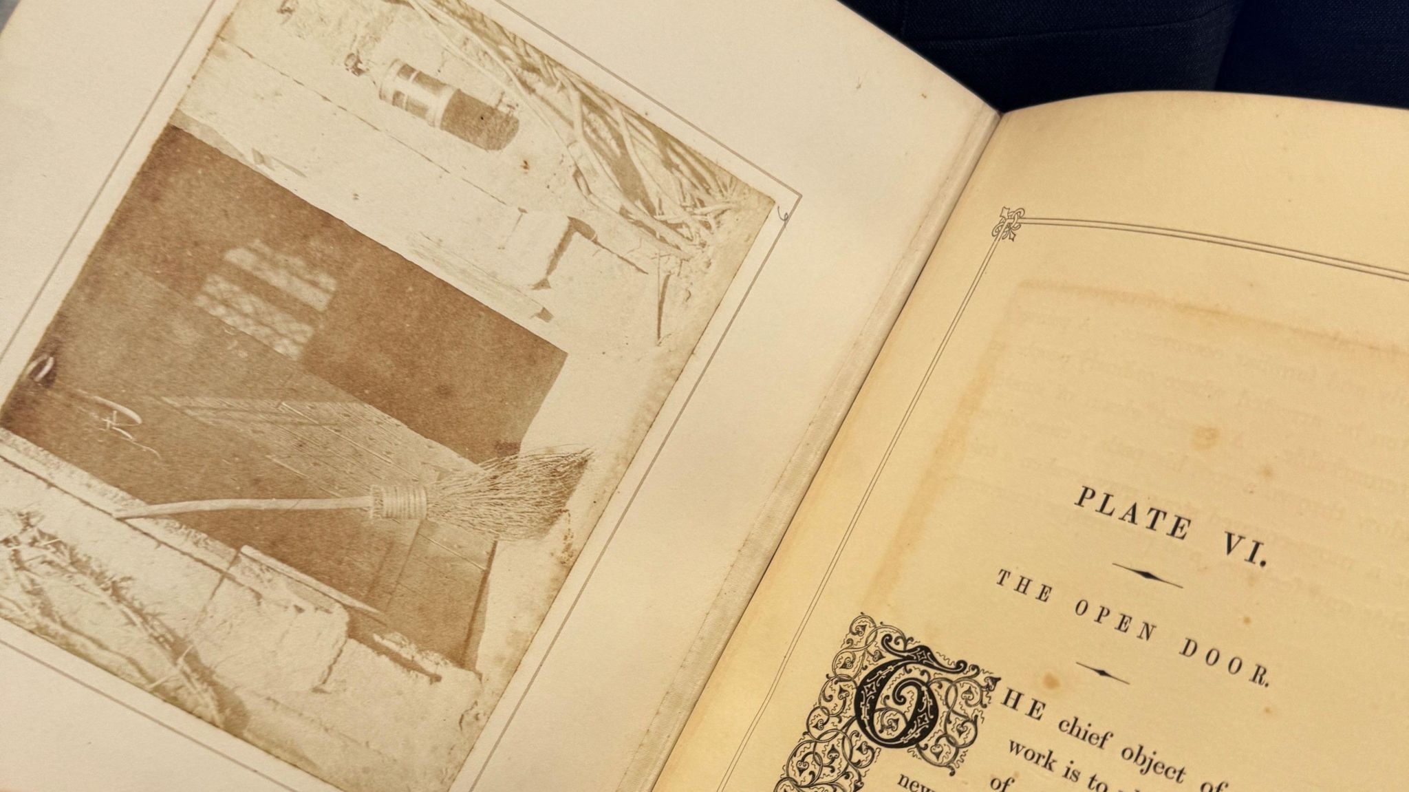 A close-up of one of Fox Talbot's books, containing an image of an open door with a broom next to it