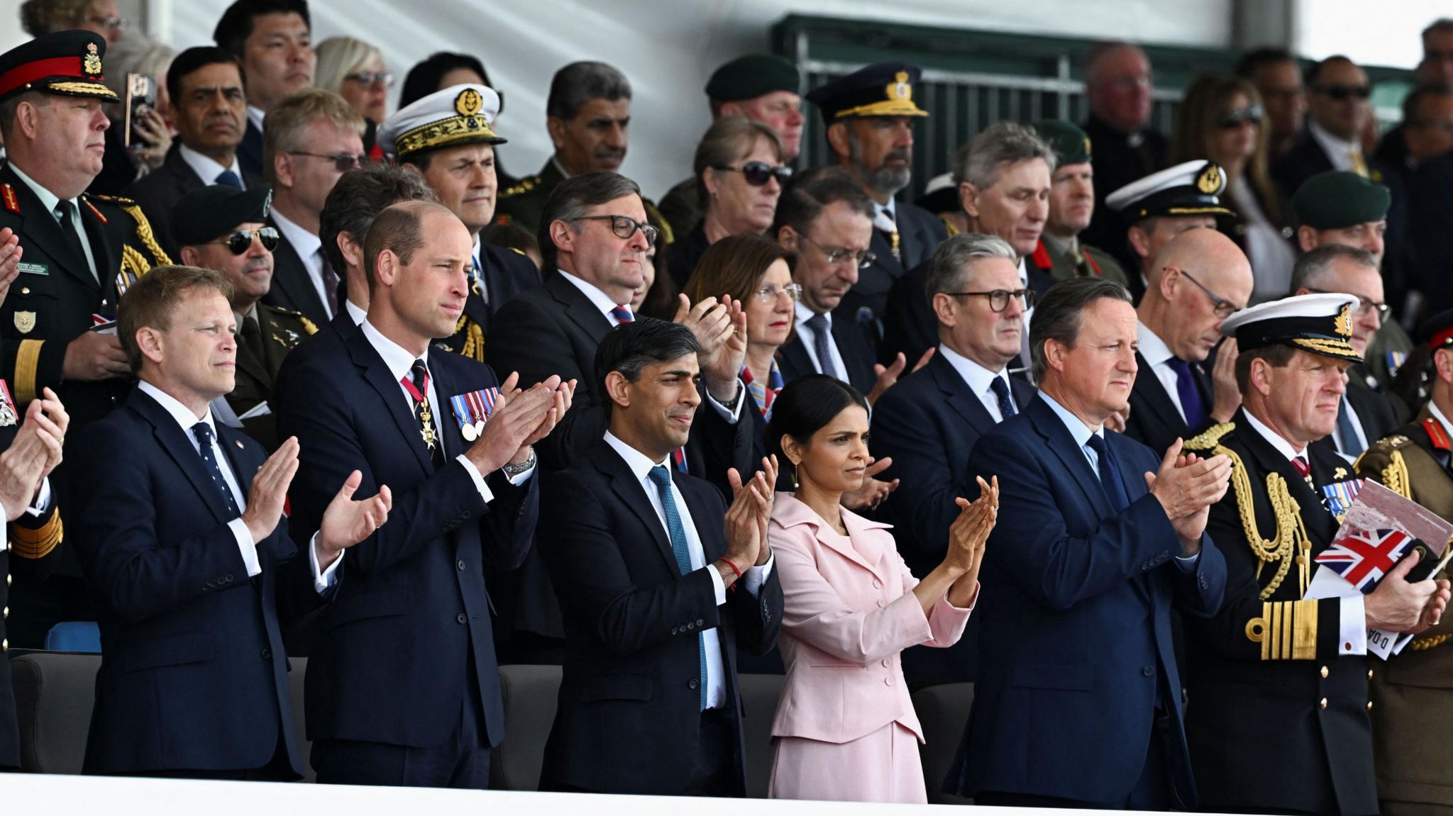 Secretary of State for Defence Grant Shapps, the Prince of Wales, Prime Minister Rishi Sunak and his wife Akshata Murty, Labour Party leader Sir Keir Starmer and Foreign Secretary Lord David Cameron in the crowd applauding at the event in Southsea
