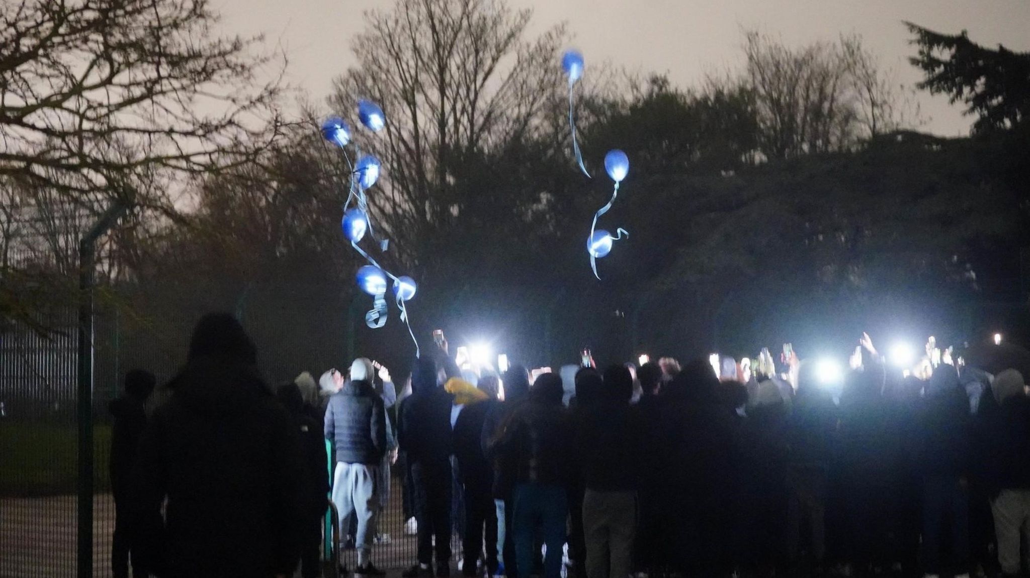 Balloons are let off at a vigil for Harry Pittman