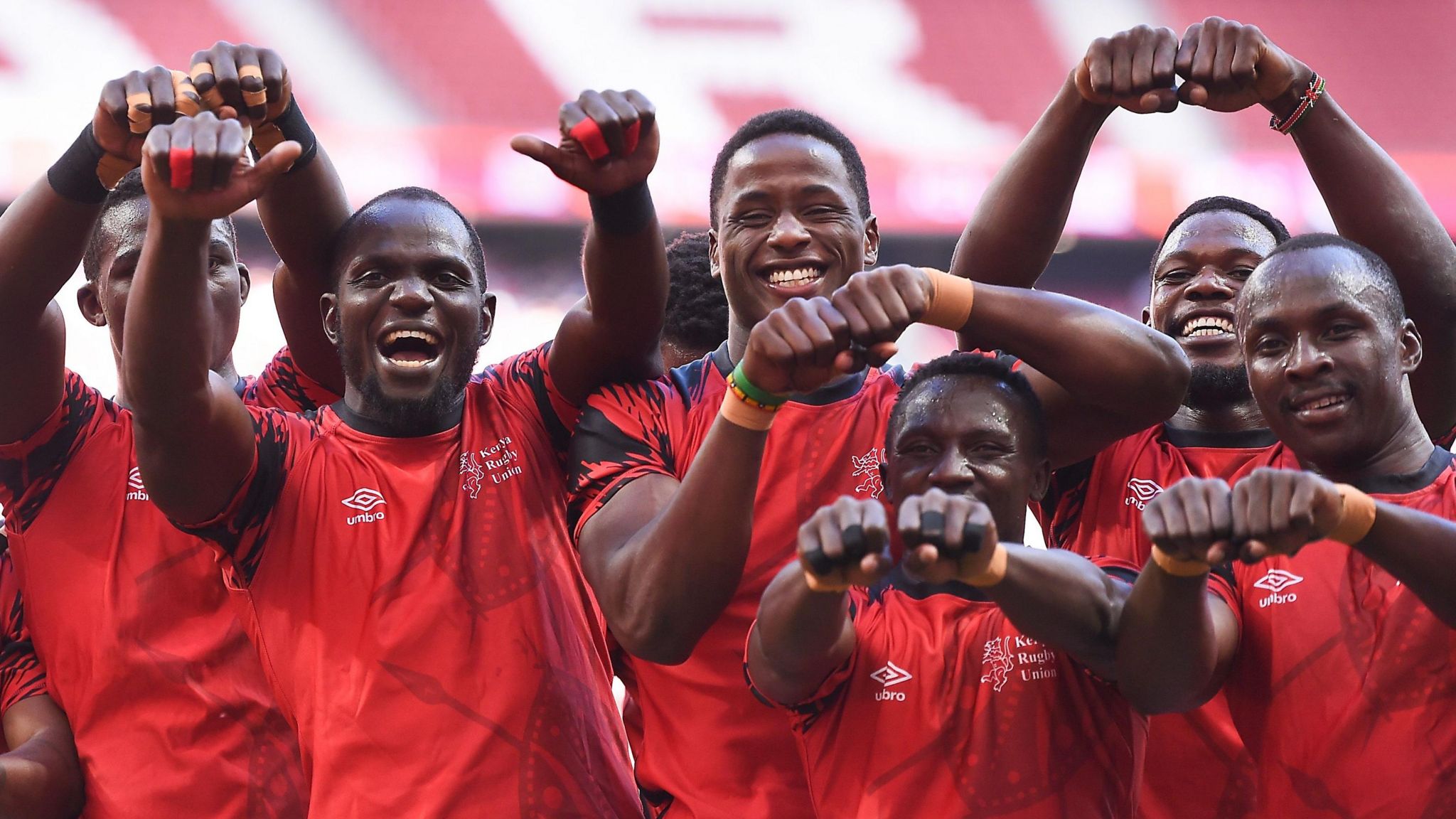 Kenya players celebrate winning a rugby sevens game by gesturing with clenched fists