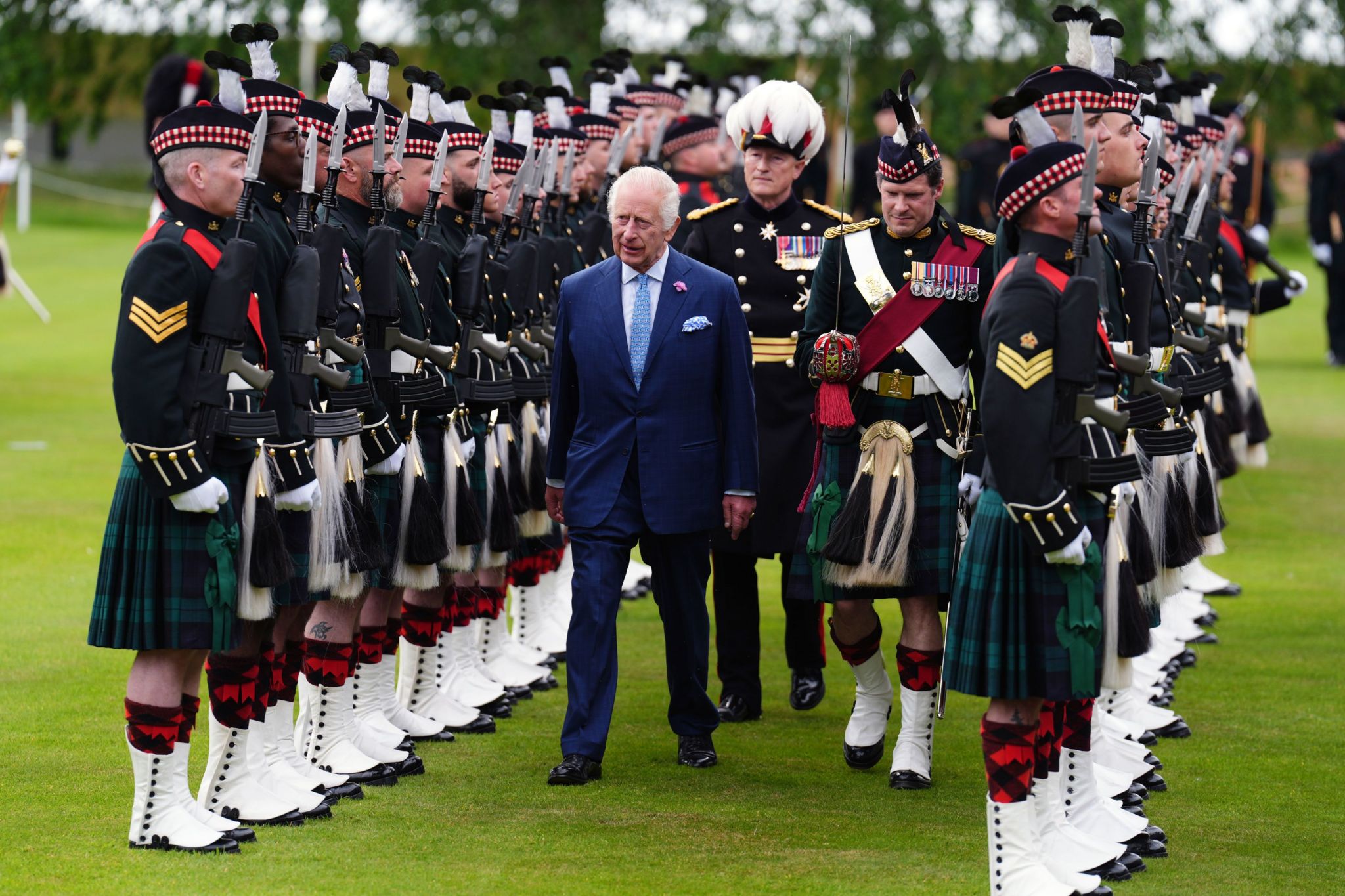 The King inspects a guard of honour in the Palace of Holyroodhouse garden