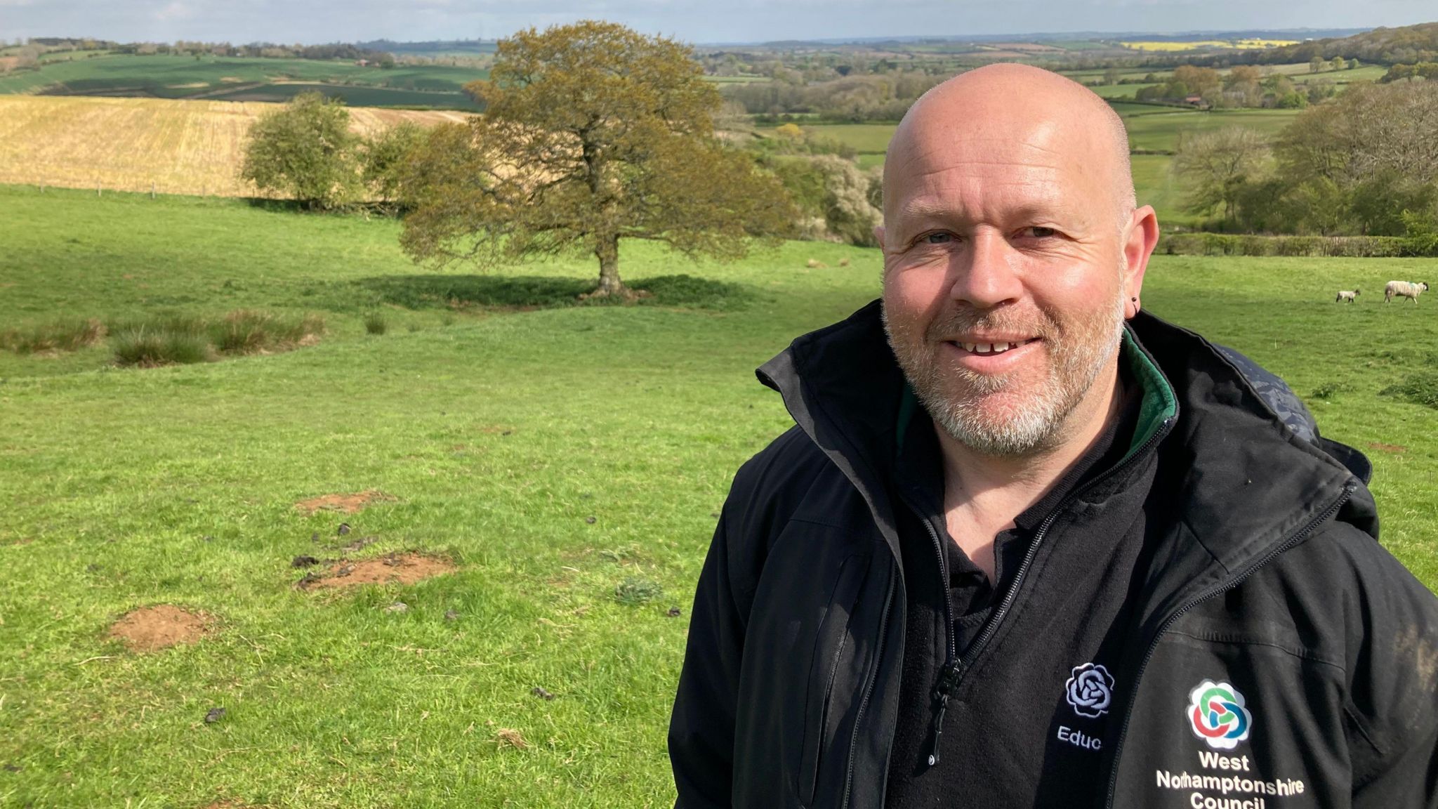 Lee Baker wearing a black outdoor raincoat in the Everdon countryside