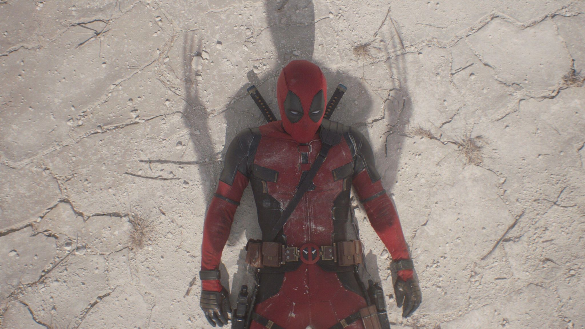 Deadpool lays on the floor with a Wolverine shadow cast over him