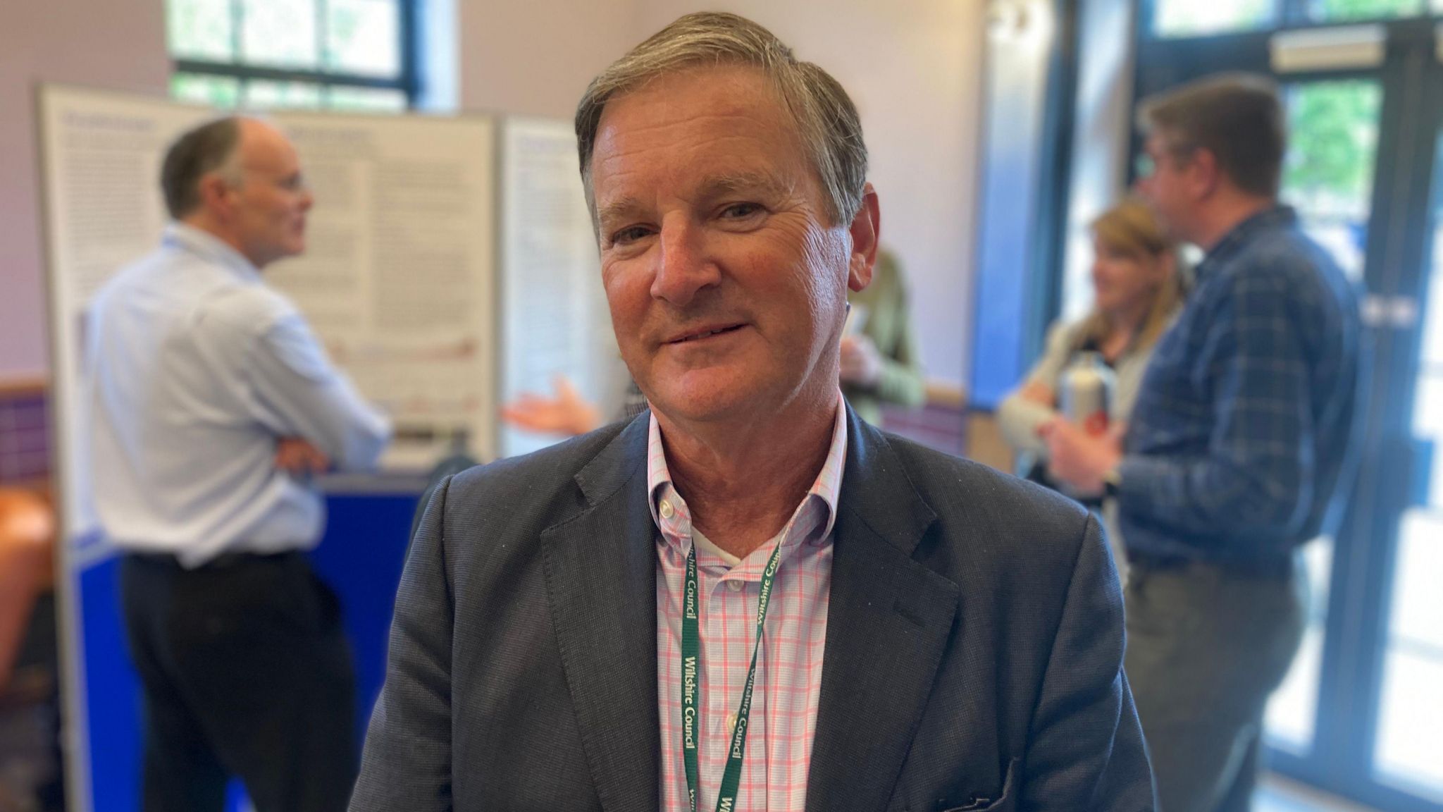 Councillor Nick Botterill at a council consultation event. He has short, grey hair and is wearing a shirt and suit jacket. He is smiling at the camera. 