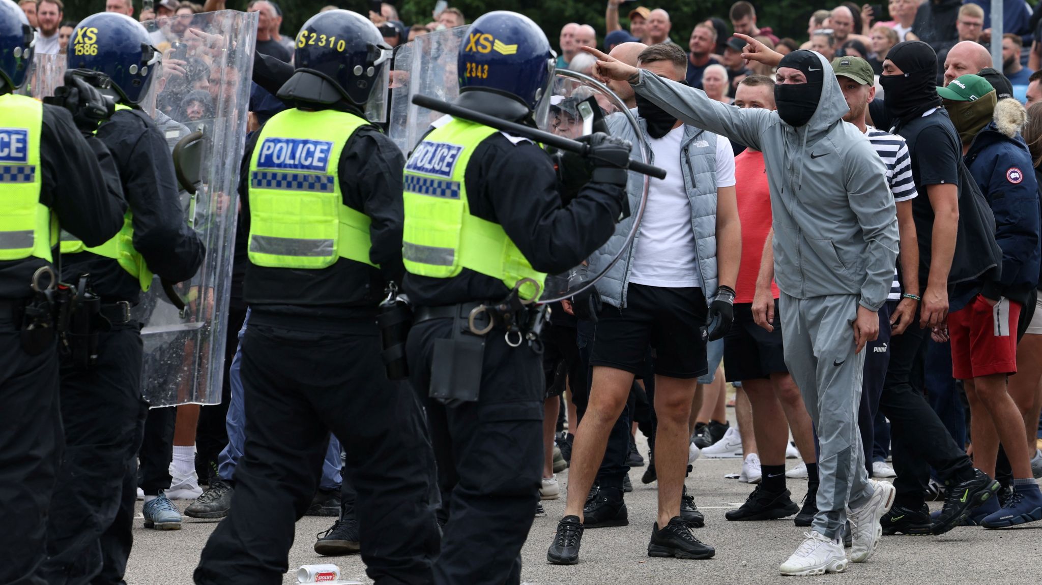 Demonstrators face police officers outside a hotel during a protest in Rotherham on Sunday