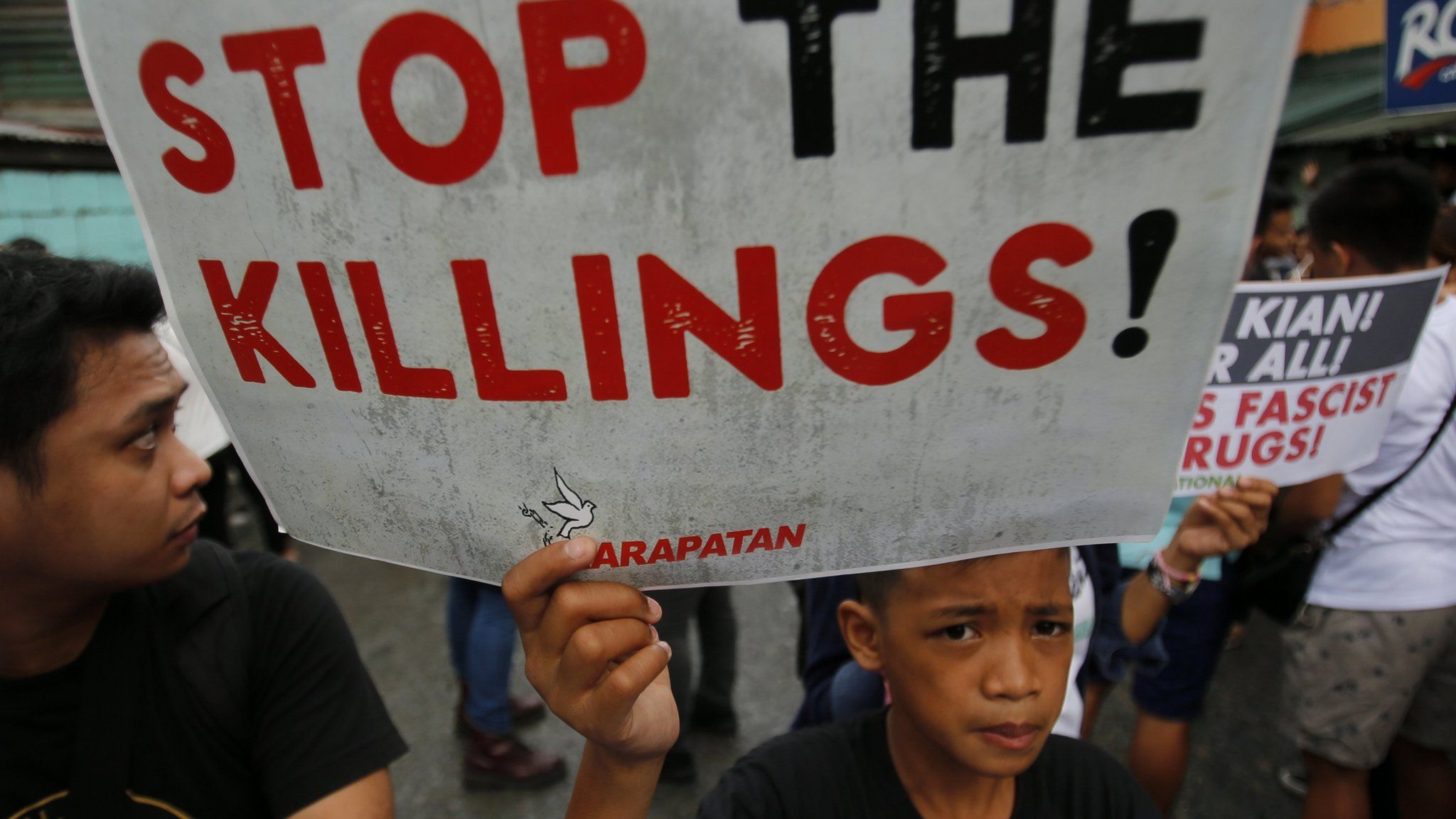 A Filipino symphatiser holds a placard while joining the funeral for student Kian Delos Santos, on a street in Manila, Philippines, 26 August 2017