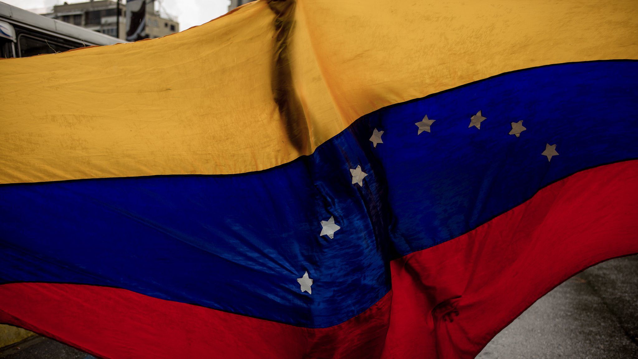 A protester holds up a Venezuelan flag at a march in Caracas