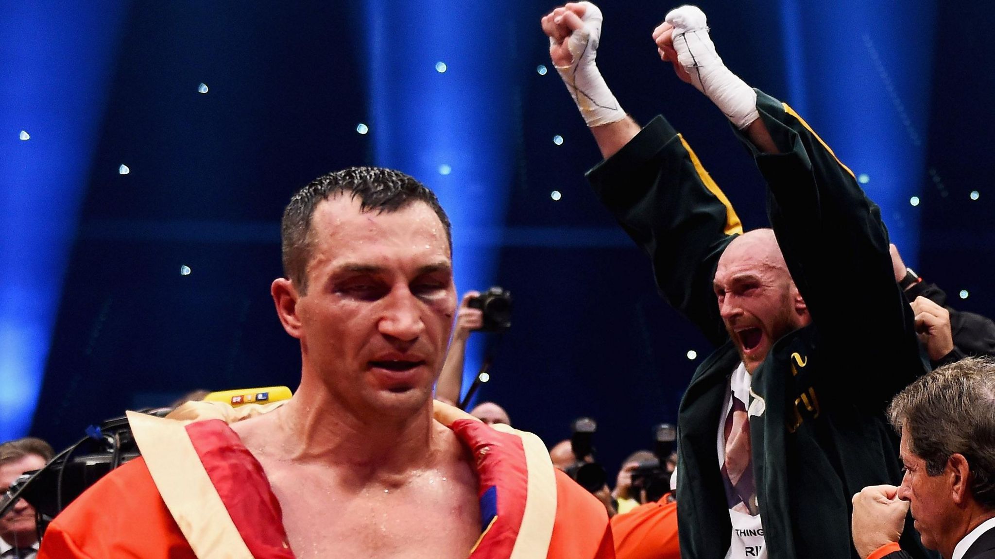 Tyson Fury celebrates while a bruised Wladimir Klitschko walks away