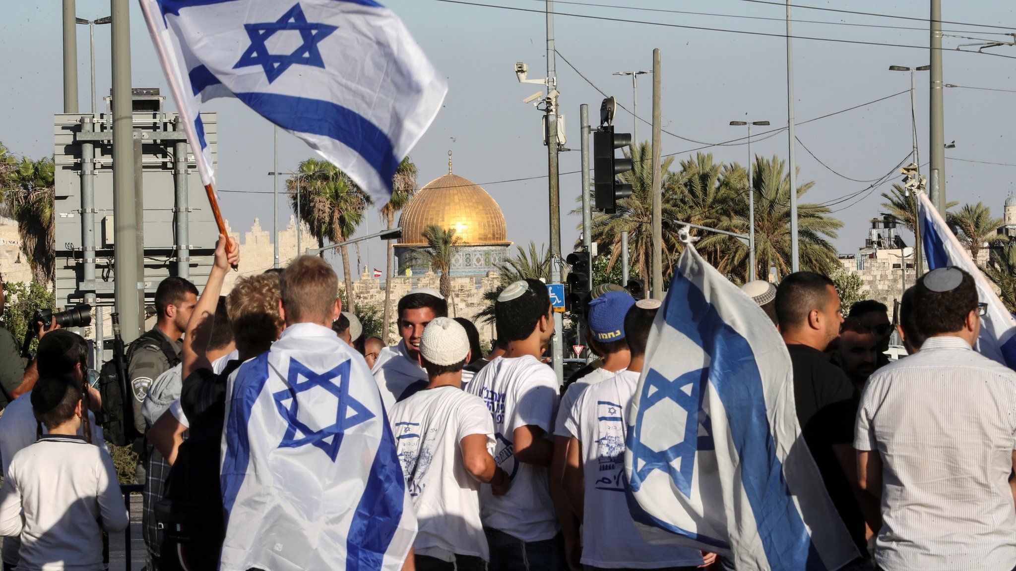 Israeli men hold Israeli flags outside Jerusalem's Old City (15 June 2021)