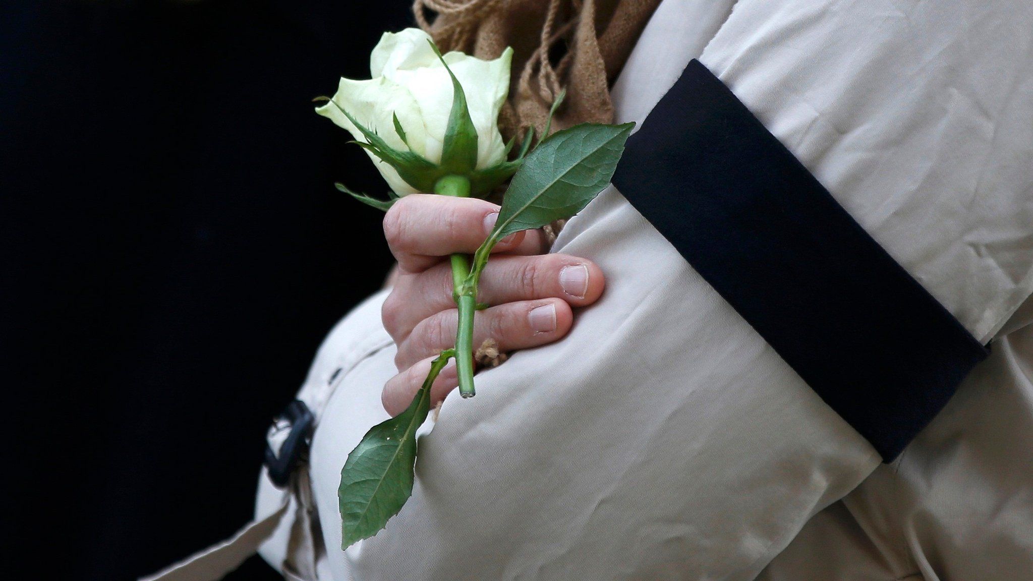 A woman holding a white rose