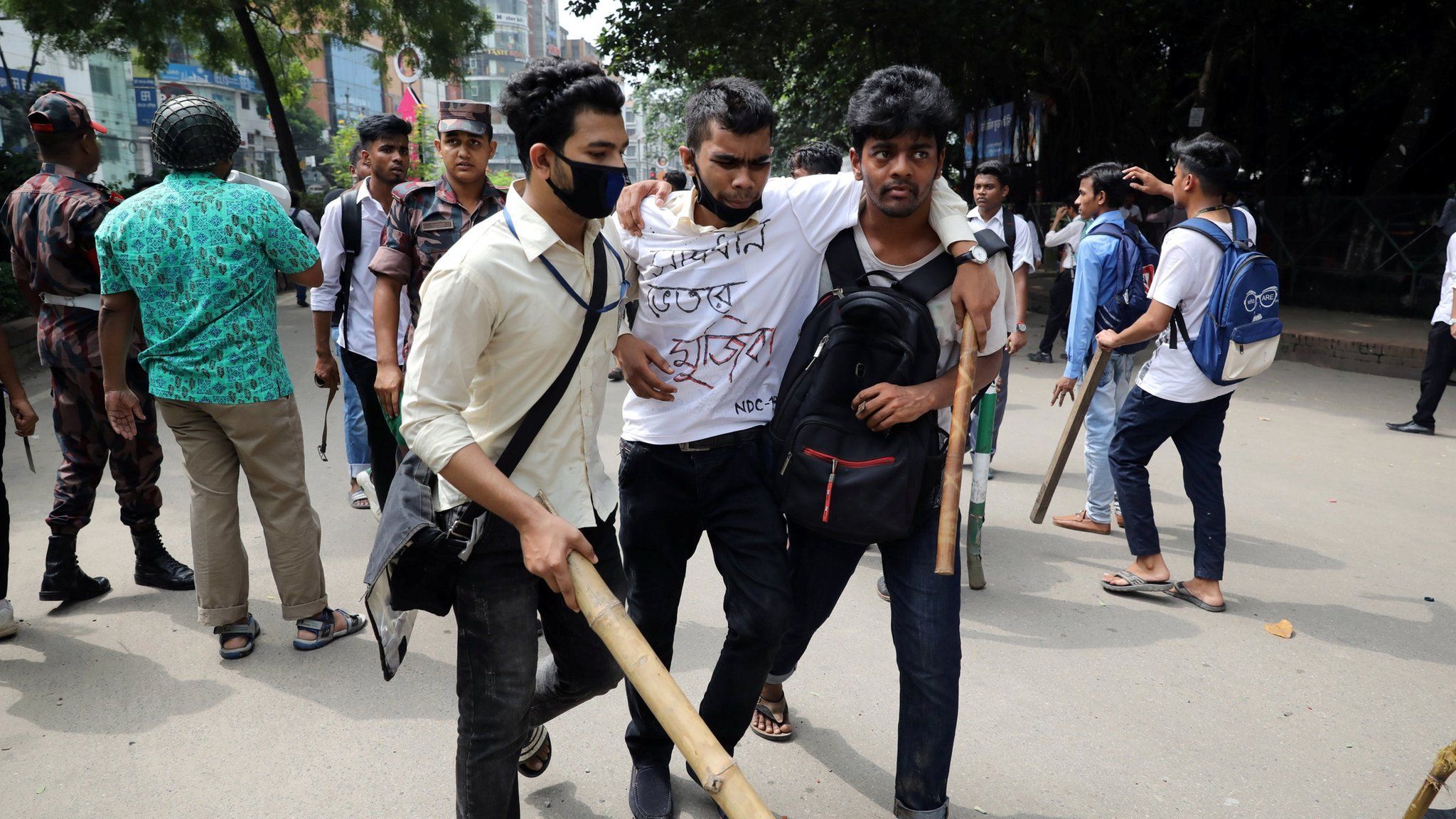 Injured student helped by fellow students during clashes - 4 August