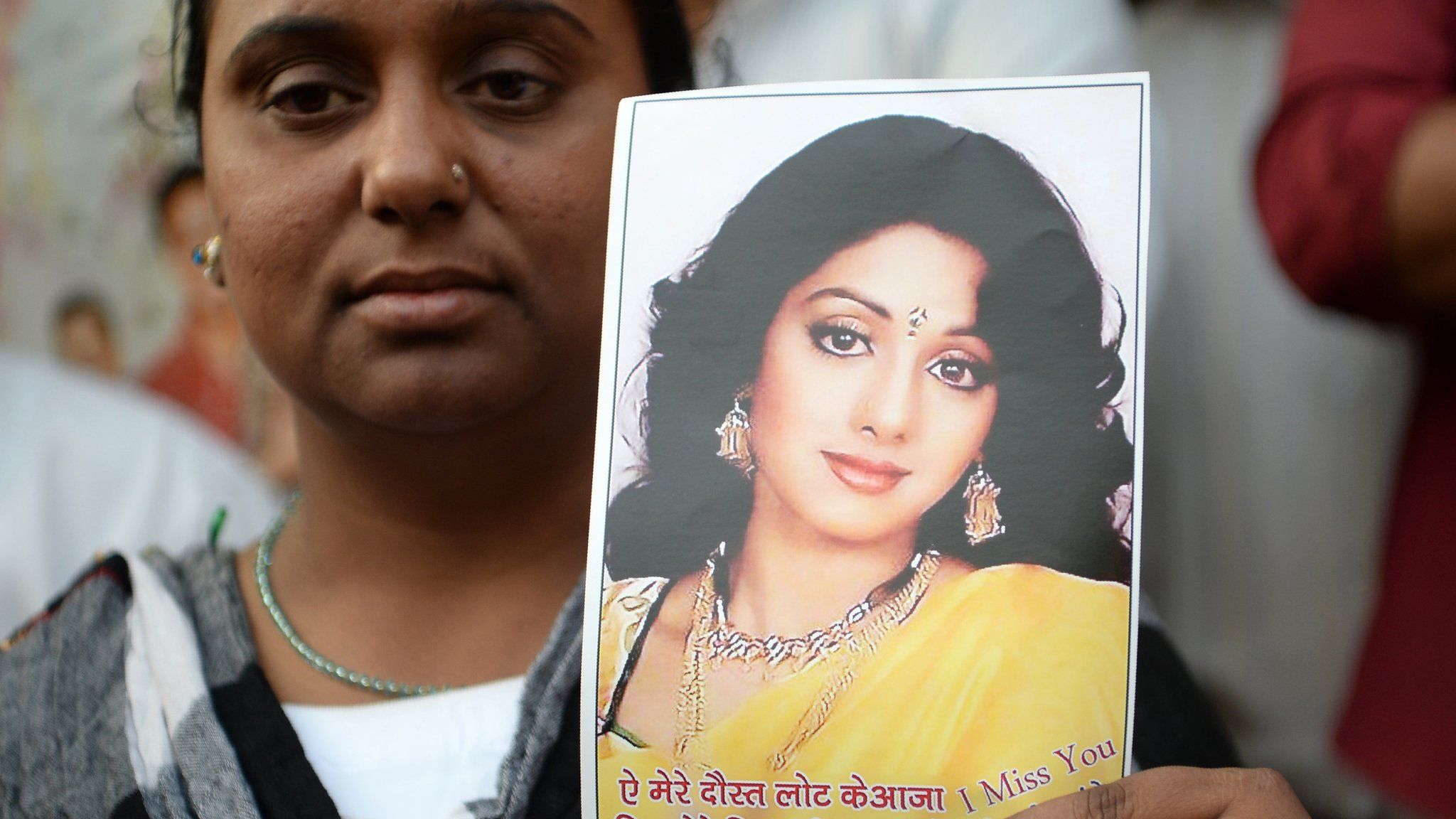 A fan of Sridevi holds up a picture of the star
