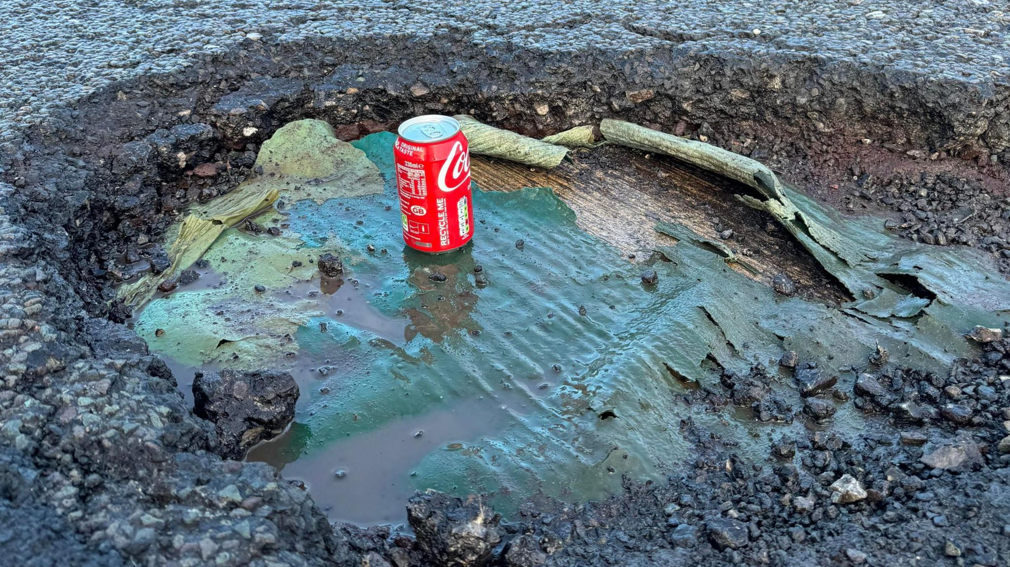 A Coke can is used to illustrate the depth of a pothole on the A64 in Leeds