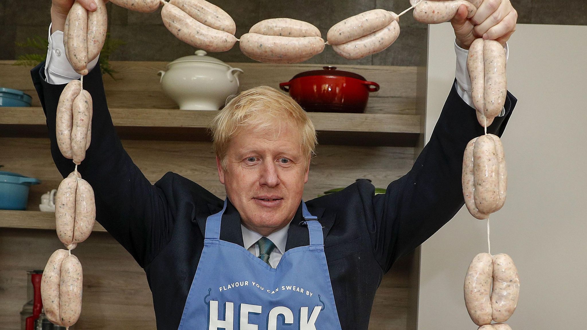 Boris Johnson holding sausages above his head