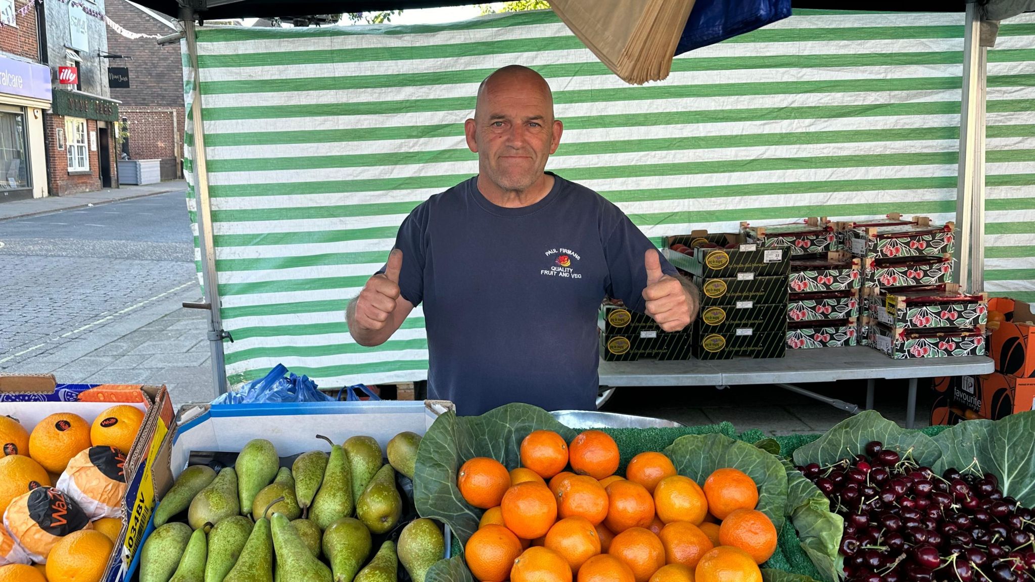 Paul Firman behind a fruit and vegetable stall 
