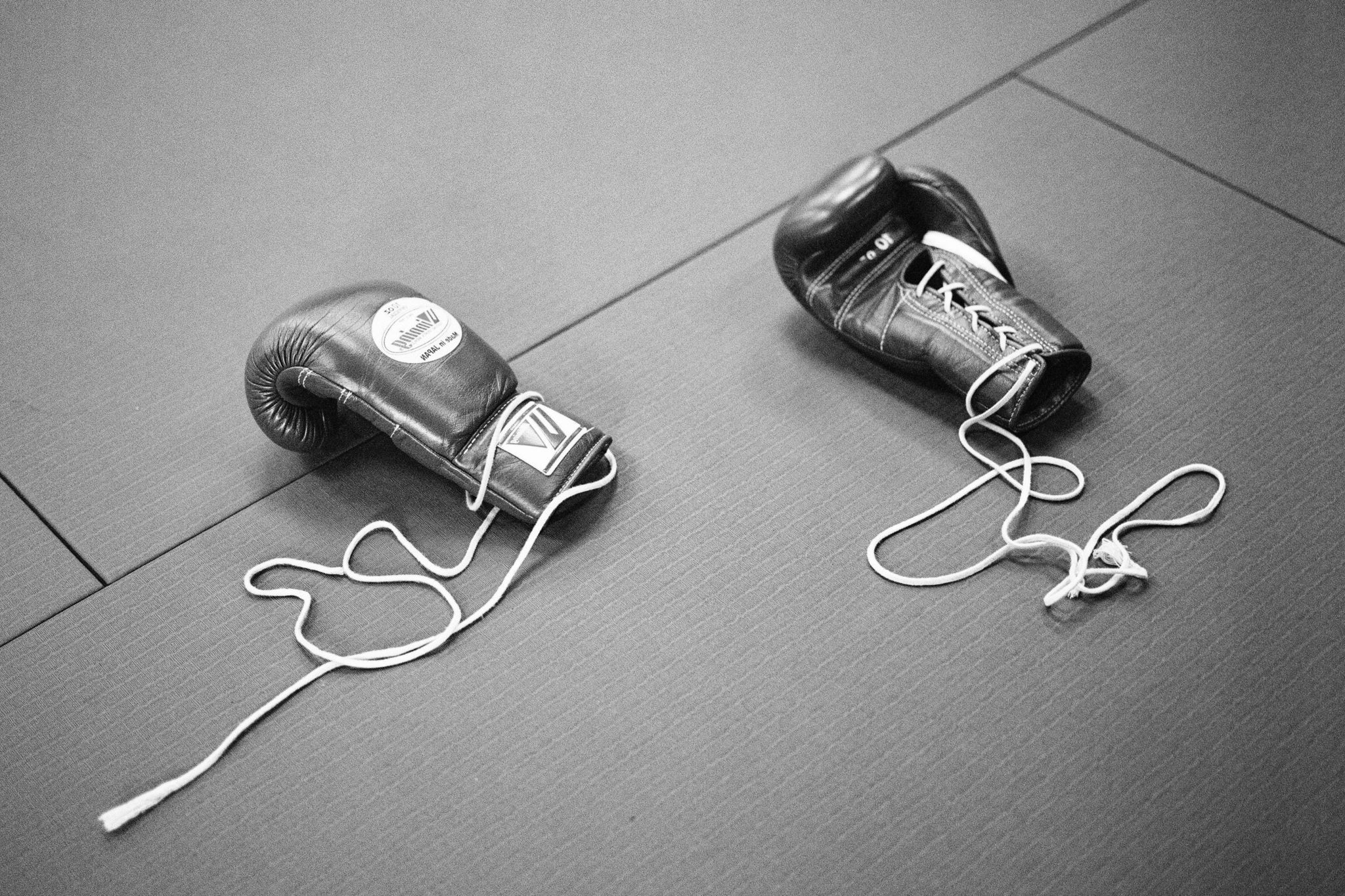 Two discarded sparring gloves on the gym floor