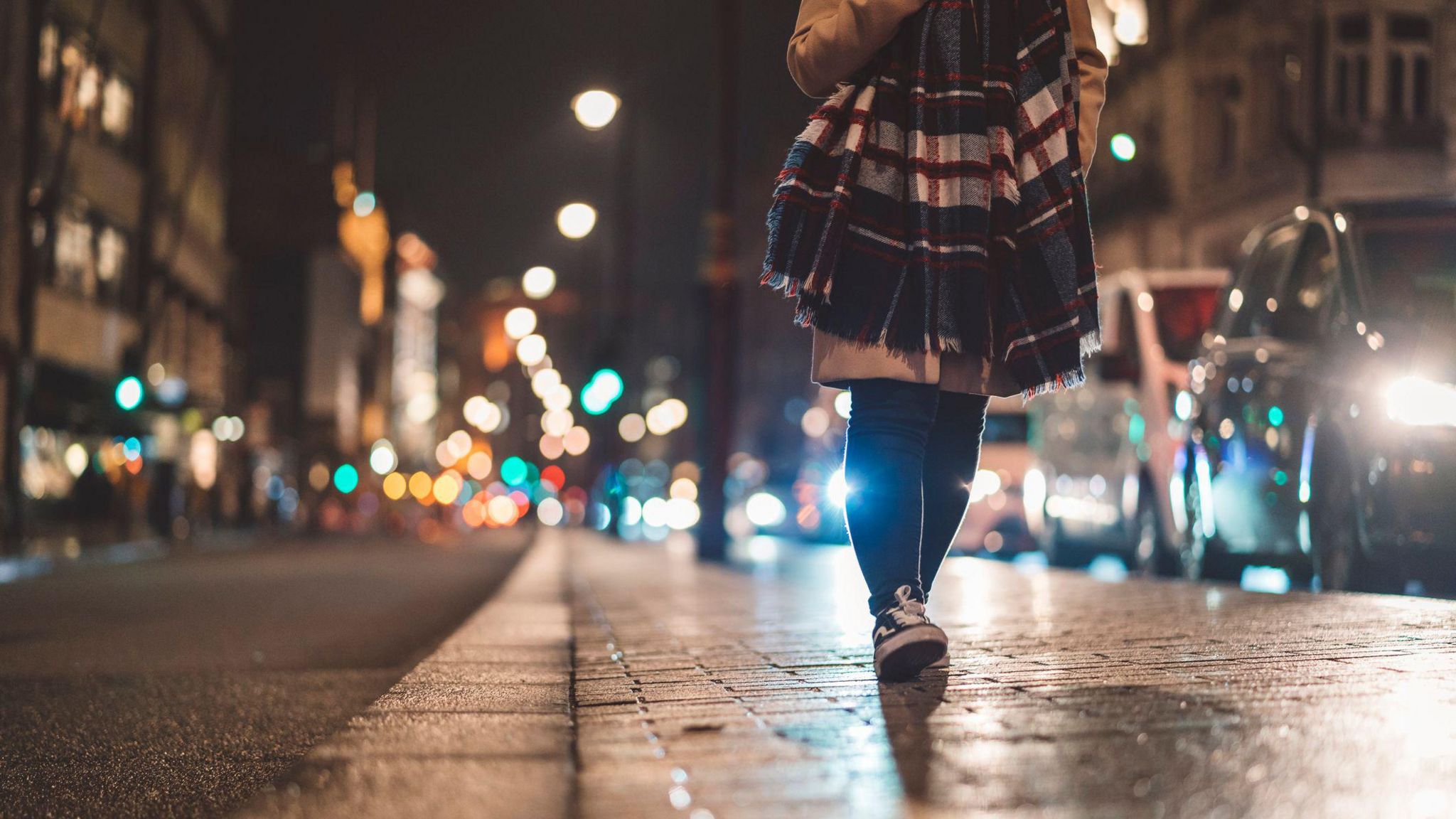 Woman walking along footpath in at night