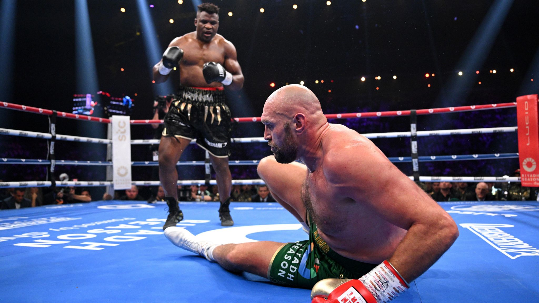 Tyson Fury attempts to get his feet while Francis Ngannou looks on