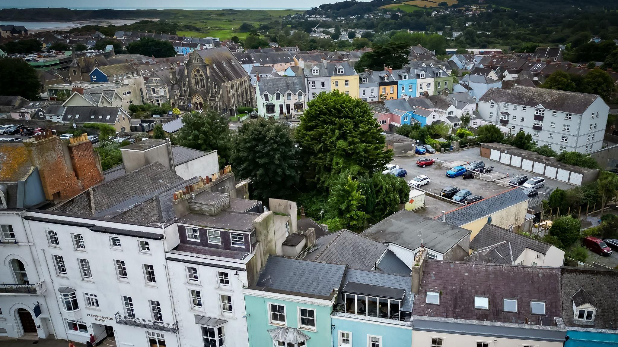 Aerial shot of Tenby showing the town's colourful terraced housing the and sea in the  distance