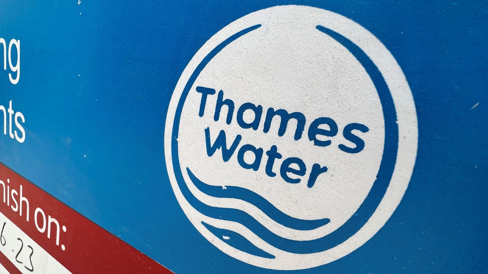 Signage is seen for British utility company Thames Water at a repair site in London