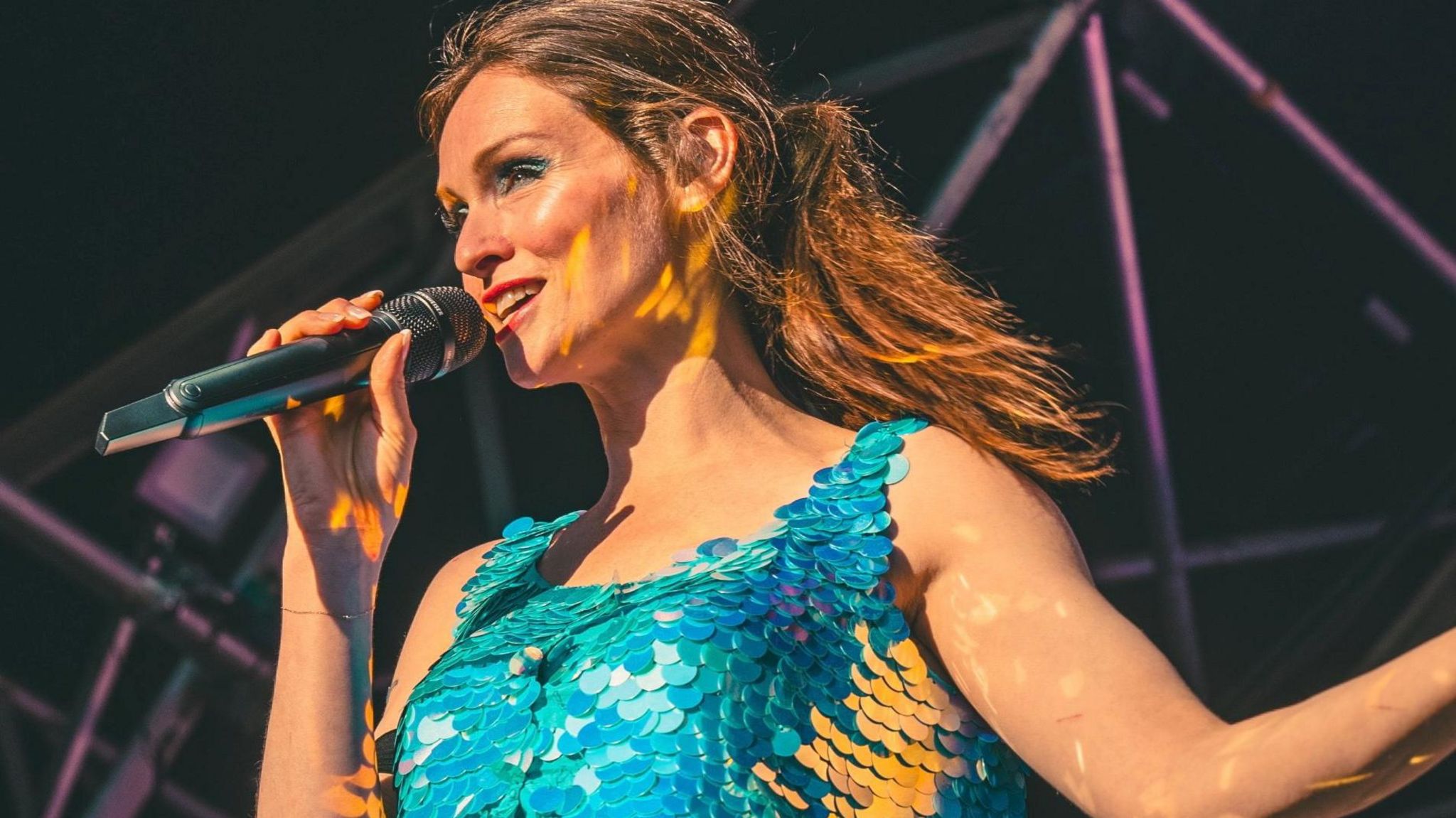 Sophie Ellis-Bexter on stage with a microphone wearing a blue sequin tank top