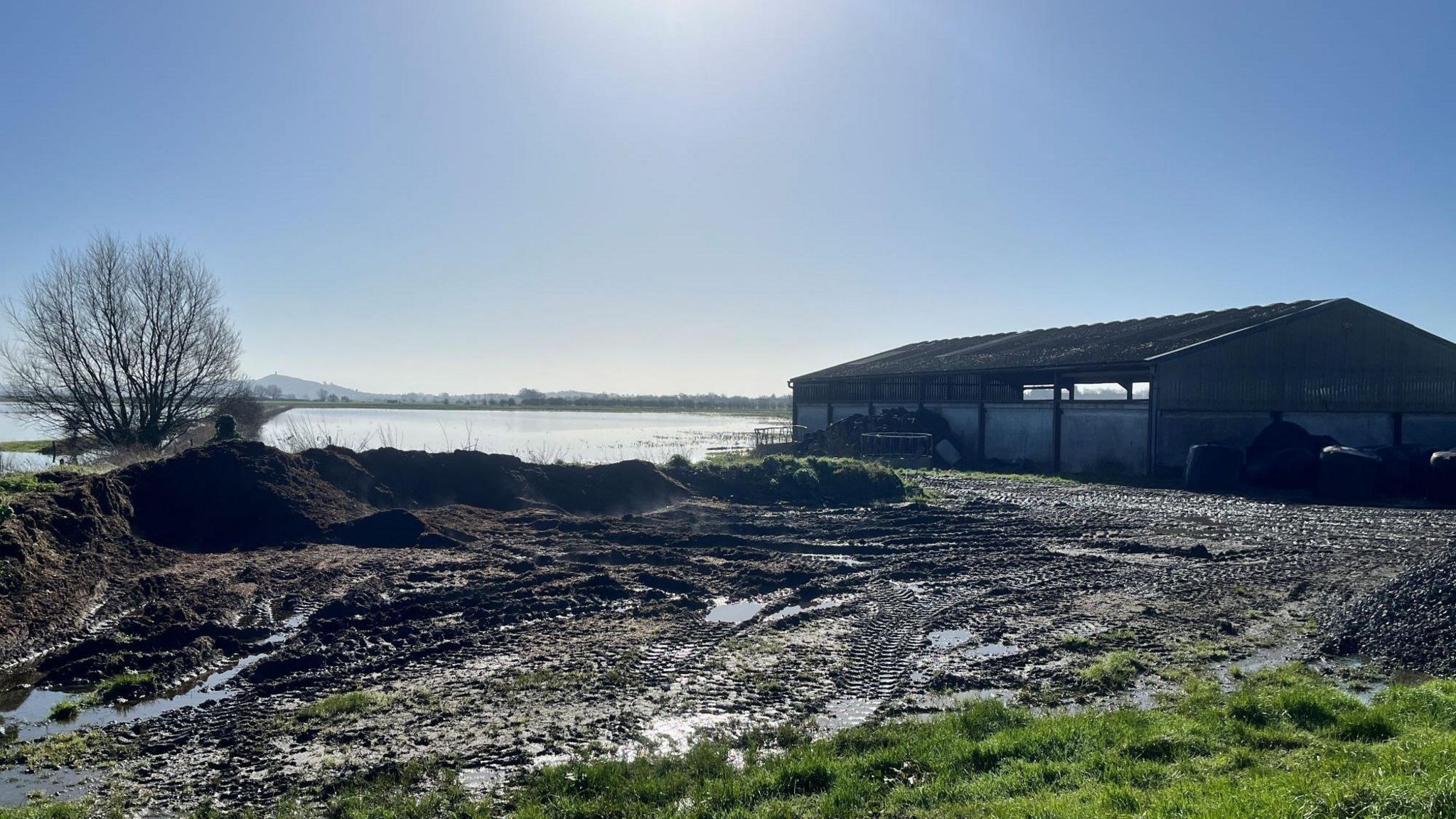 A farm building surrounded by floodwater