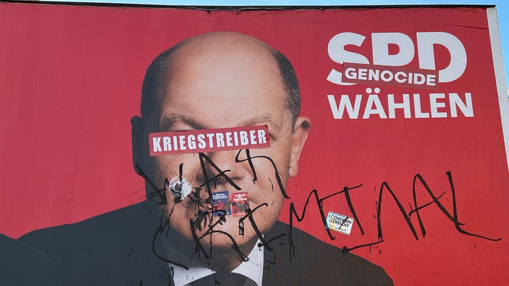 Berlin's graffiti artists label Olaf Scholz a warmonger in German and a war criminal in English