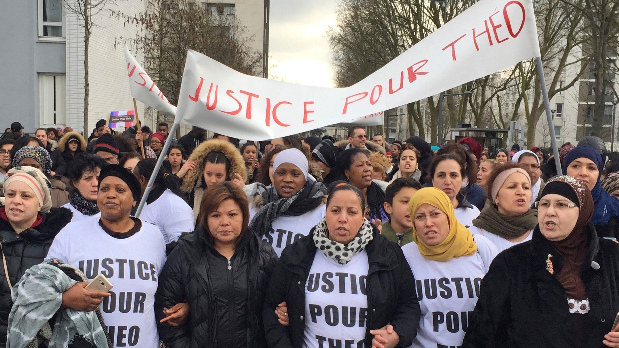 People march in the streets of Aulnay-sous-Bois, north of Paris, France, holding a sign reading "Justice for Theo" during a protest, a day after a French police officer was charged with the rape of a youth, 6 February 2017