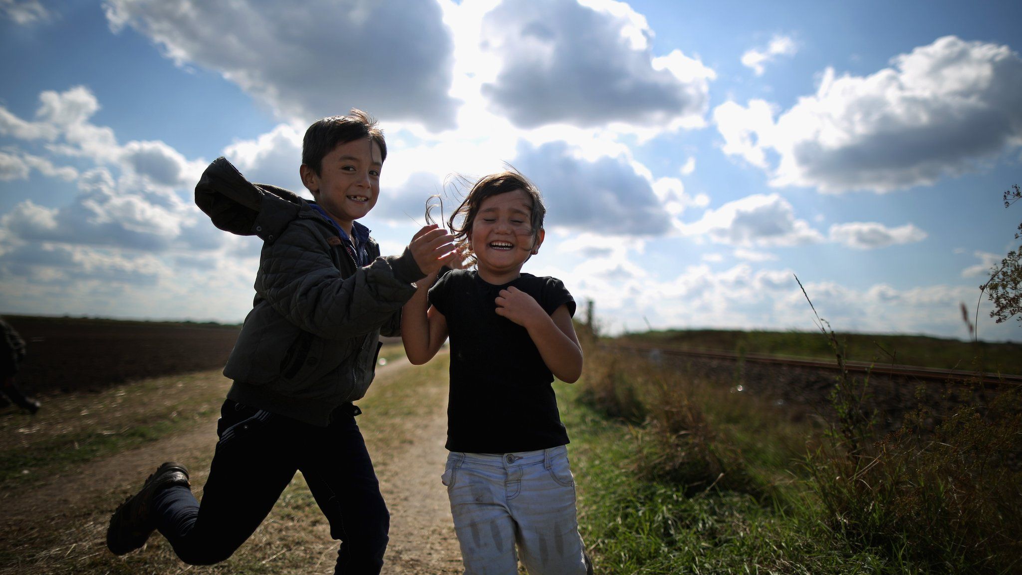 Children race each other as they cross the border from Serbia into Hungary on 6 September 2015.