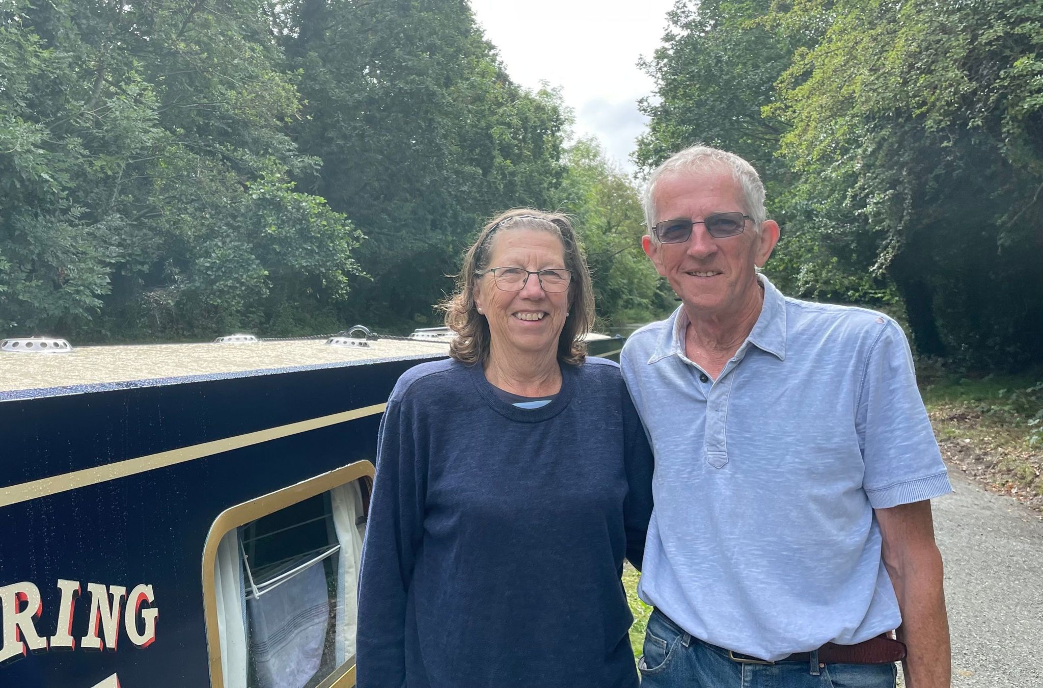 Bruce Crook and his wife Lauris standing next to a narrowboat.