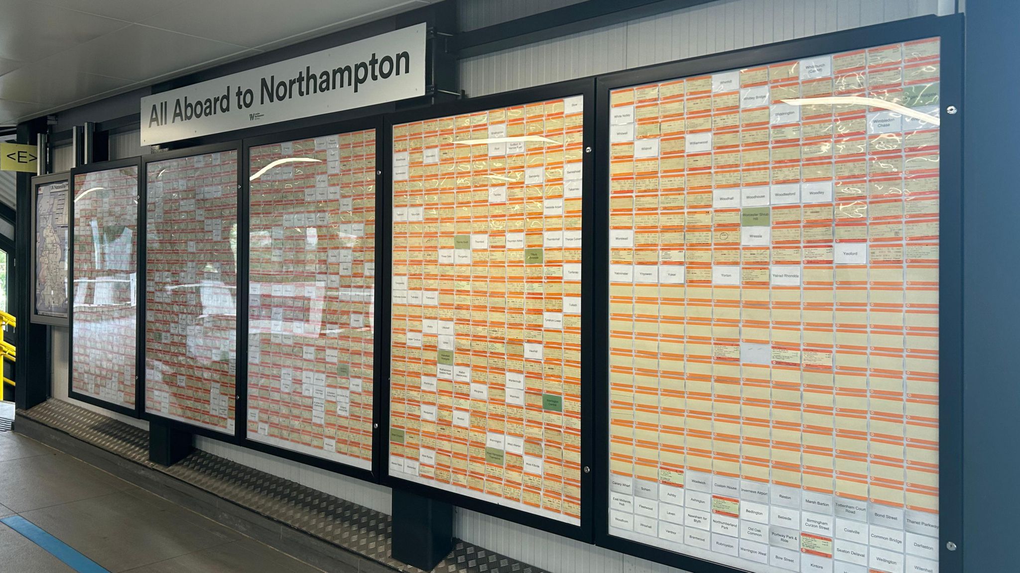 The wall of orange rail tickets with white spaces left for the missing departure points