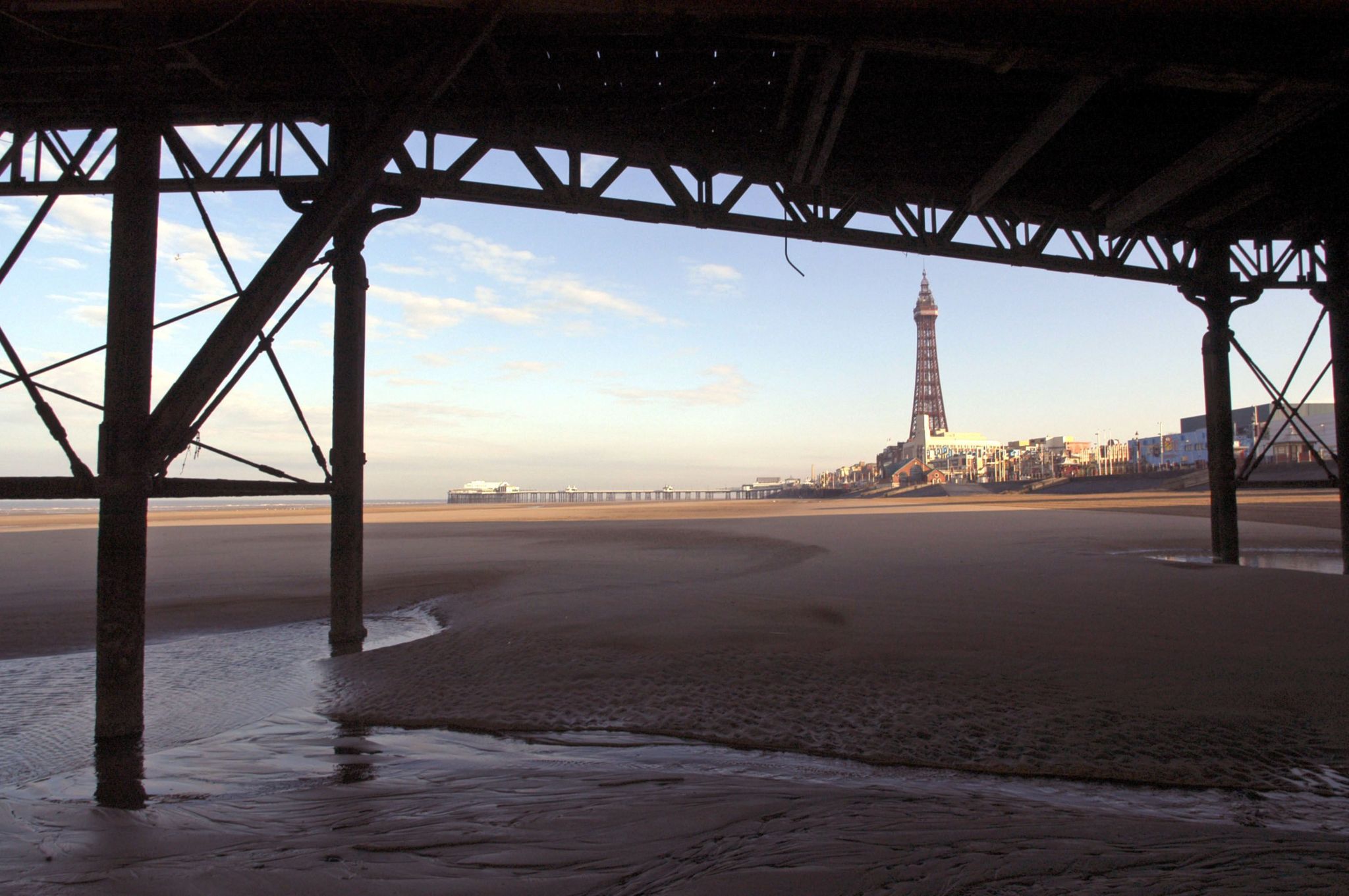 Blackpool Tower is seen from under the Central Pier at low tide on the beach at Blackpool