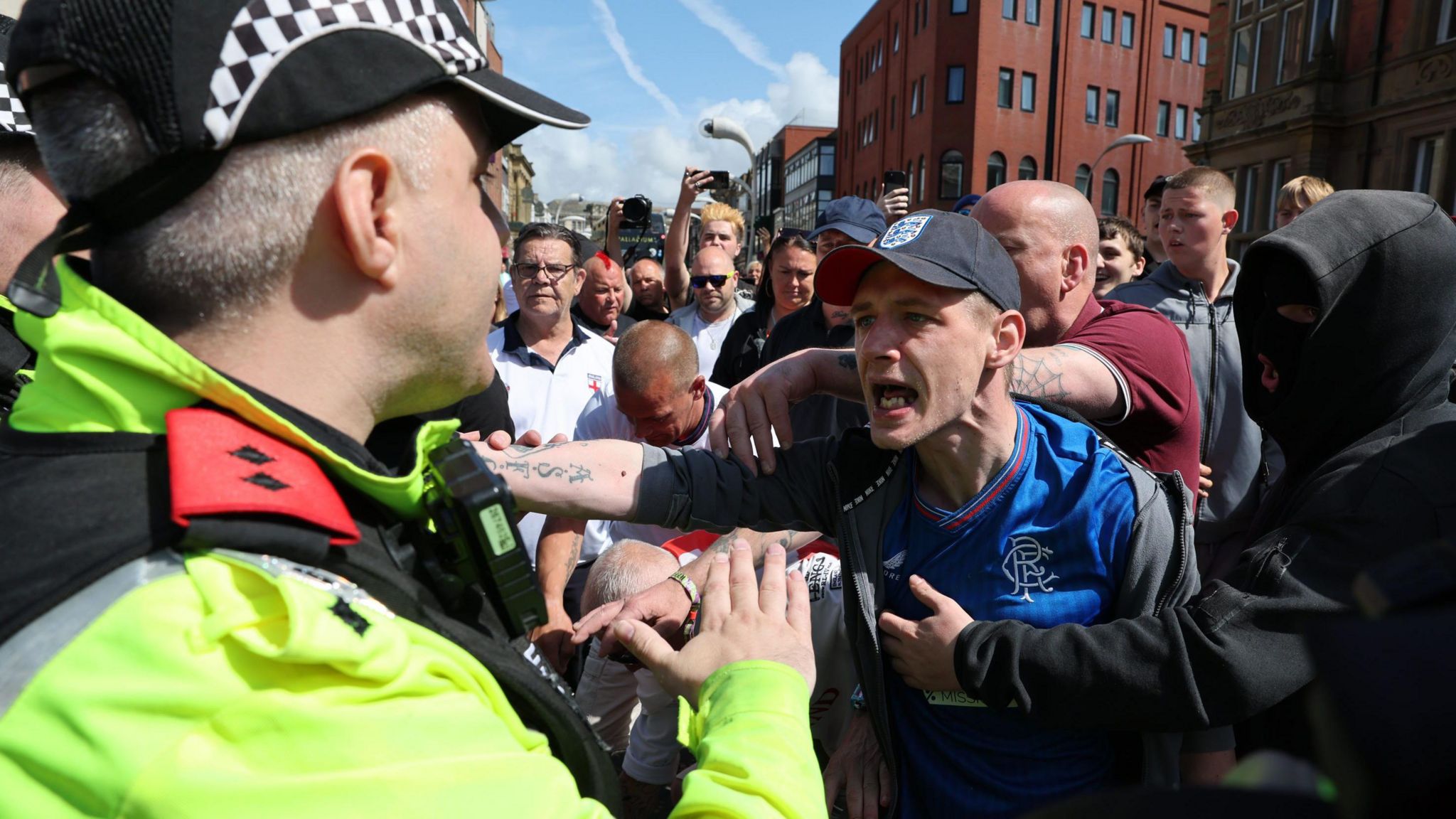 Protester shouts at police officer while surrounded by other demonstrators