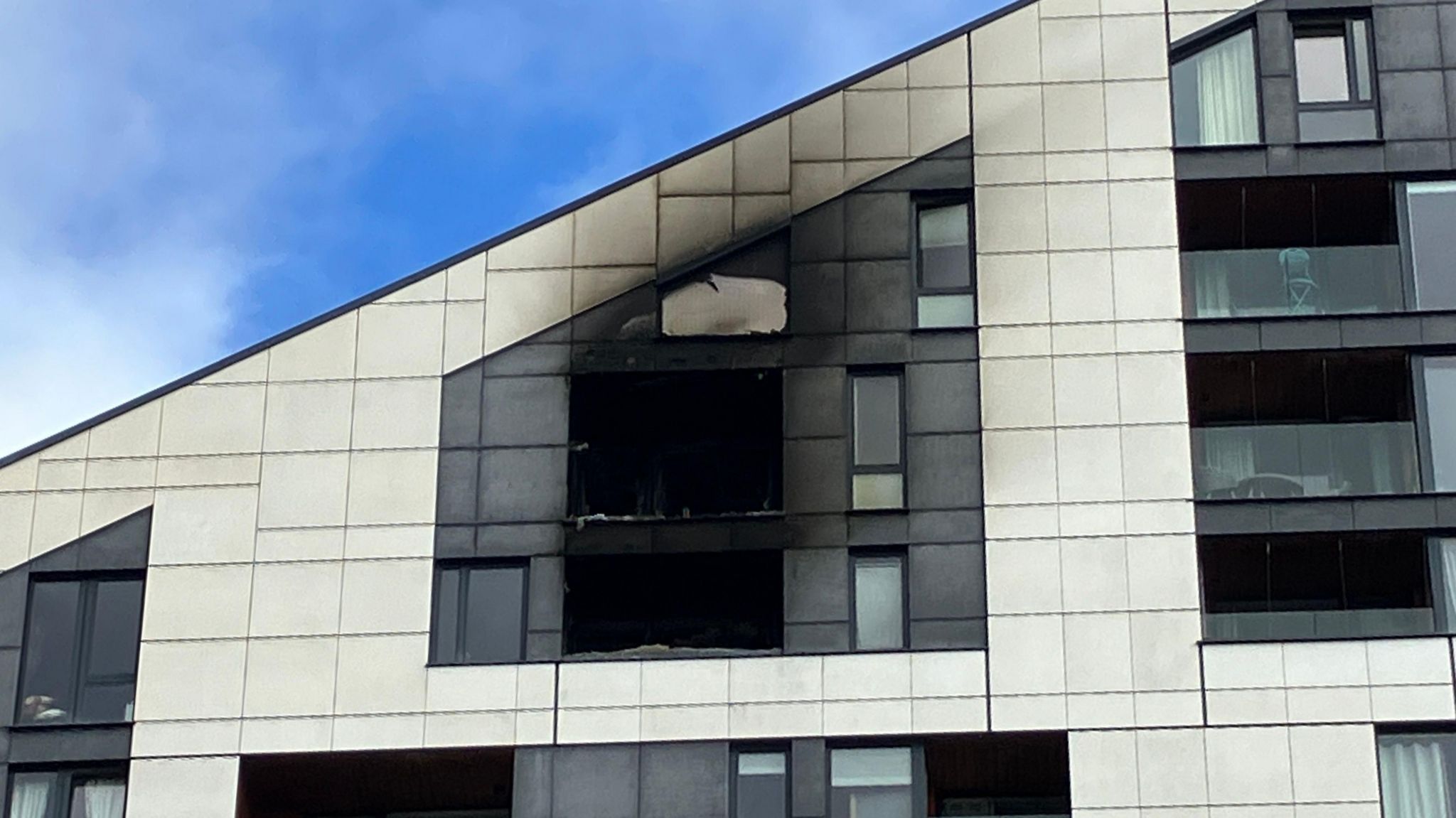 Two glass balconies are shattered and burned