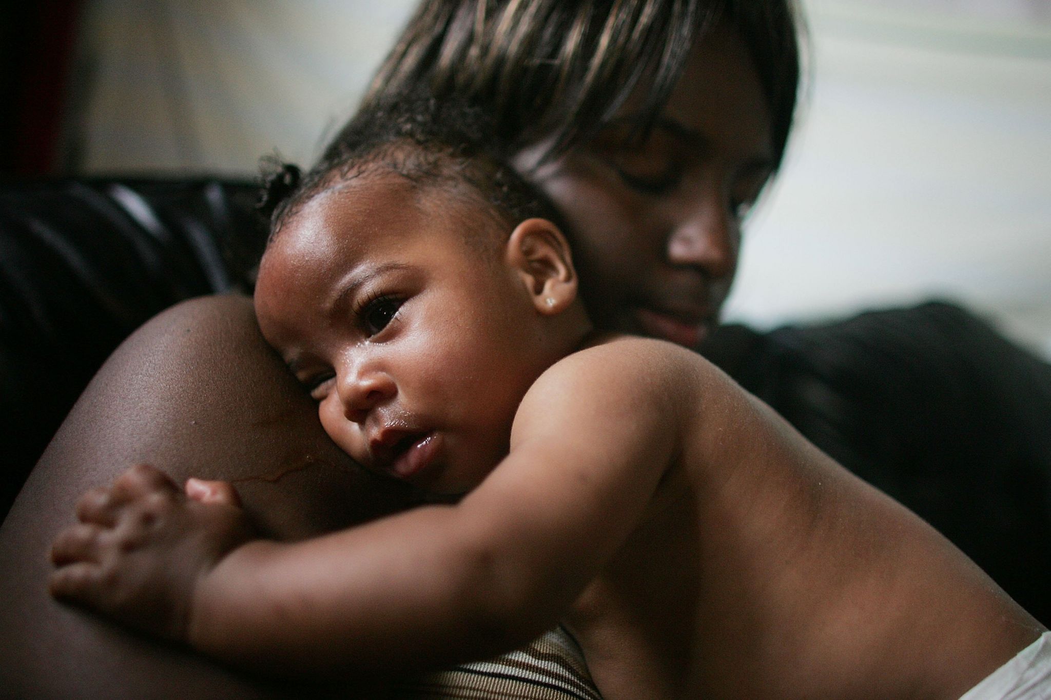 A woman, Shanika Reaux, holds her 6 month old baby Tatiana in their home