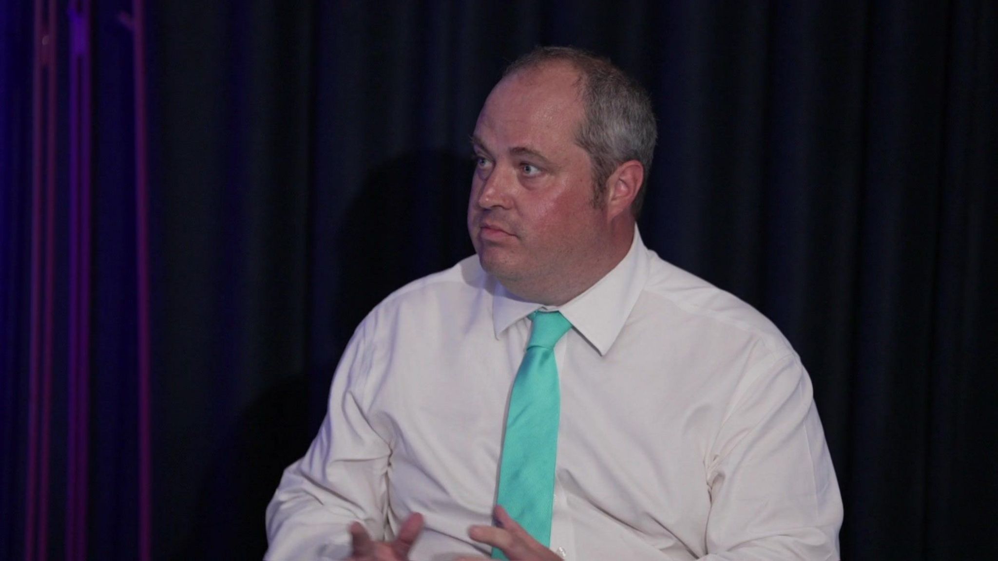 Reform UK party member Alex Wilson, wearing a white shirt and green tie