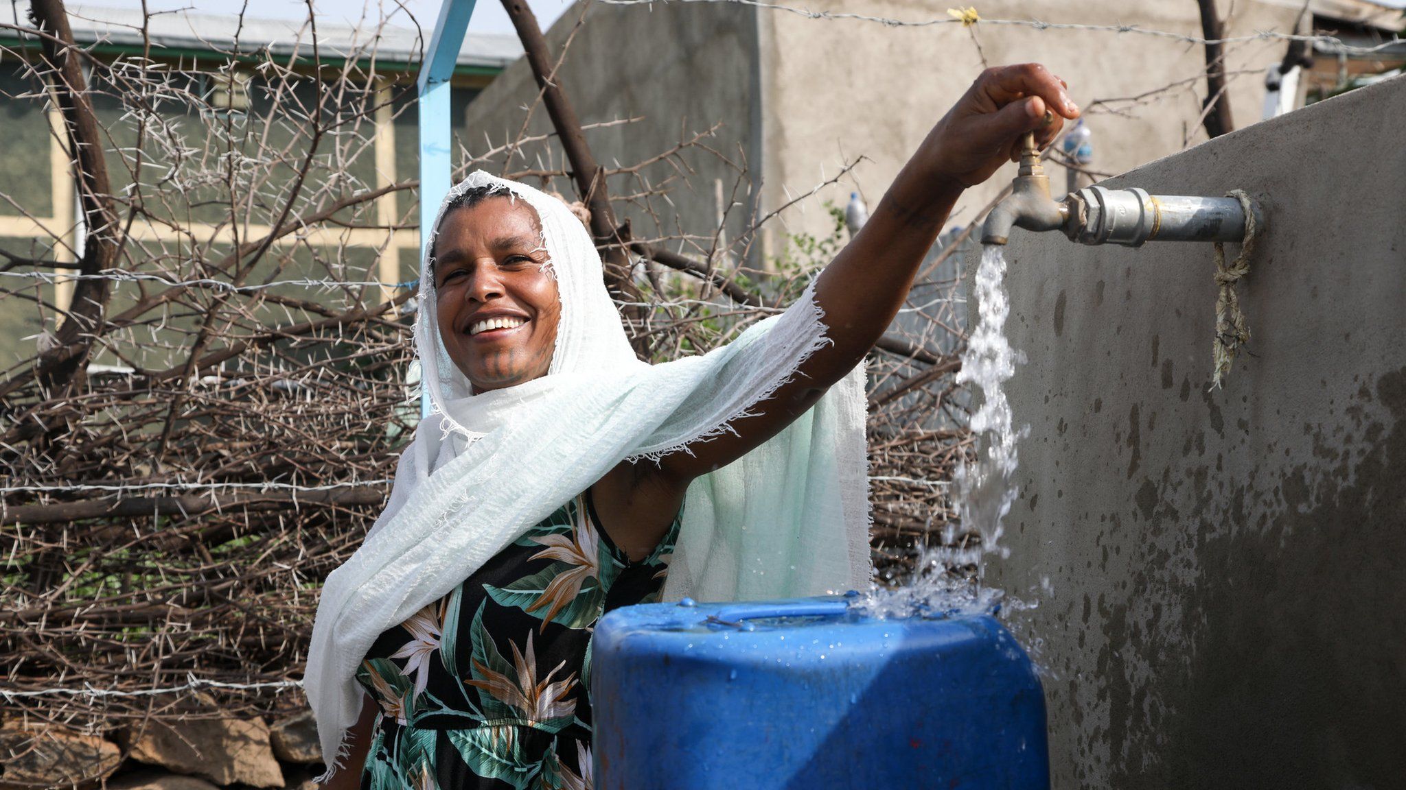 Wudenesh Negussie, 39, collects water from a local tap to take back to her family in Wolenchiti, Ethiopia, in 2019