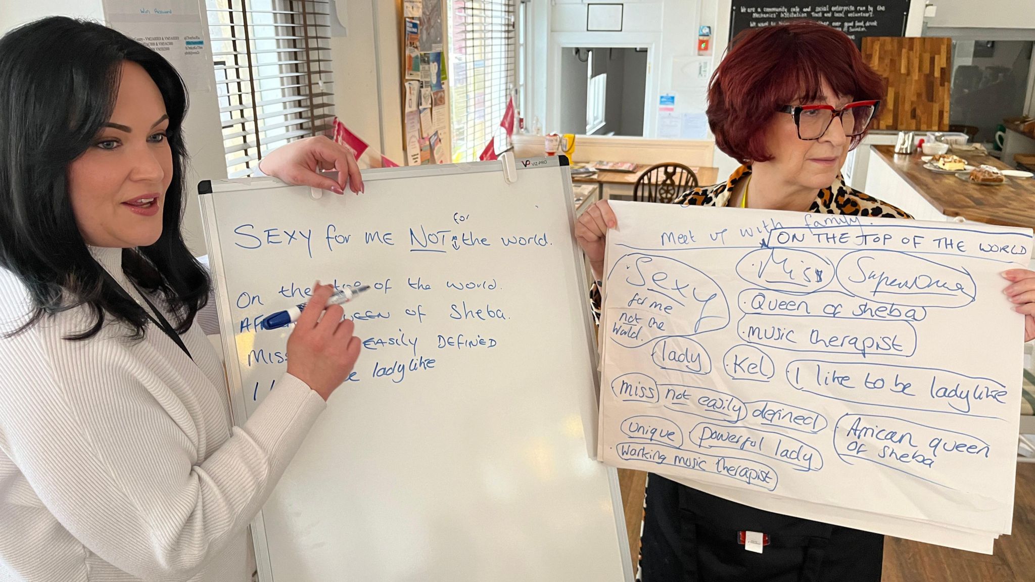 Tracy Graham and Amanda Mathieson write phrases on a board which form the lyrics to the group's song