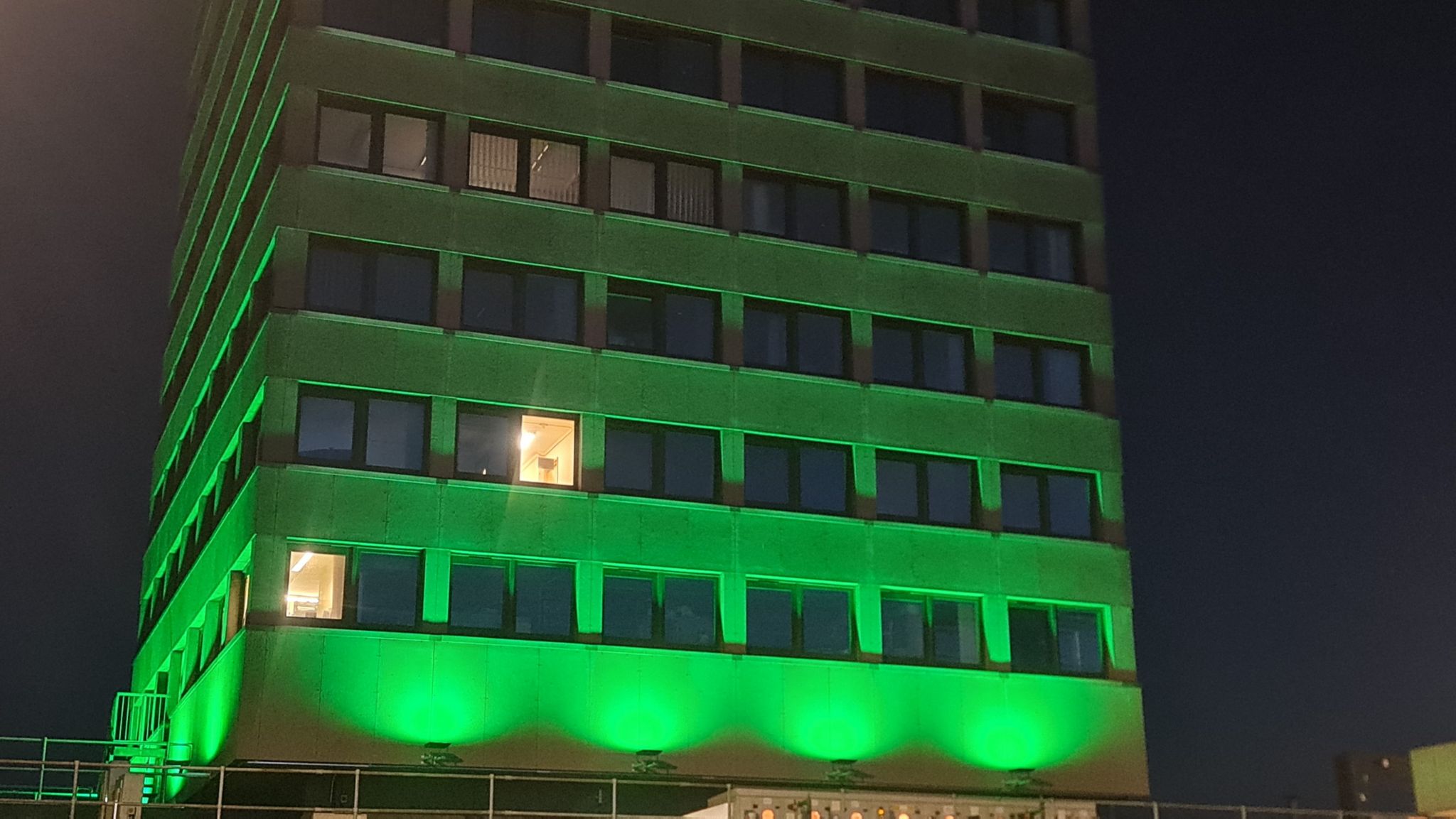 A tower block at Basildon Hospital illuminated with green lights during the hours of darkness