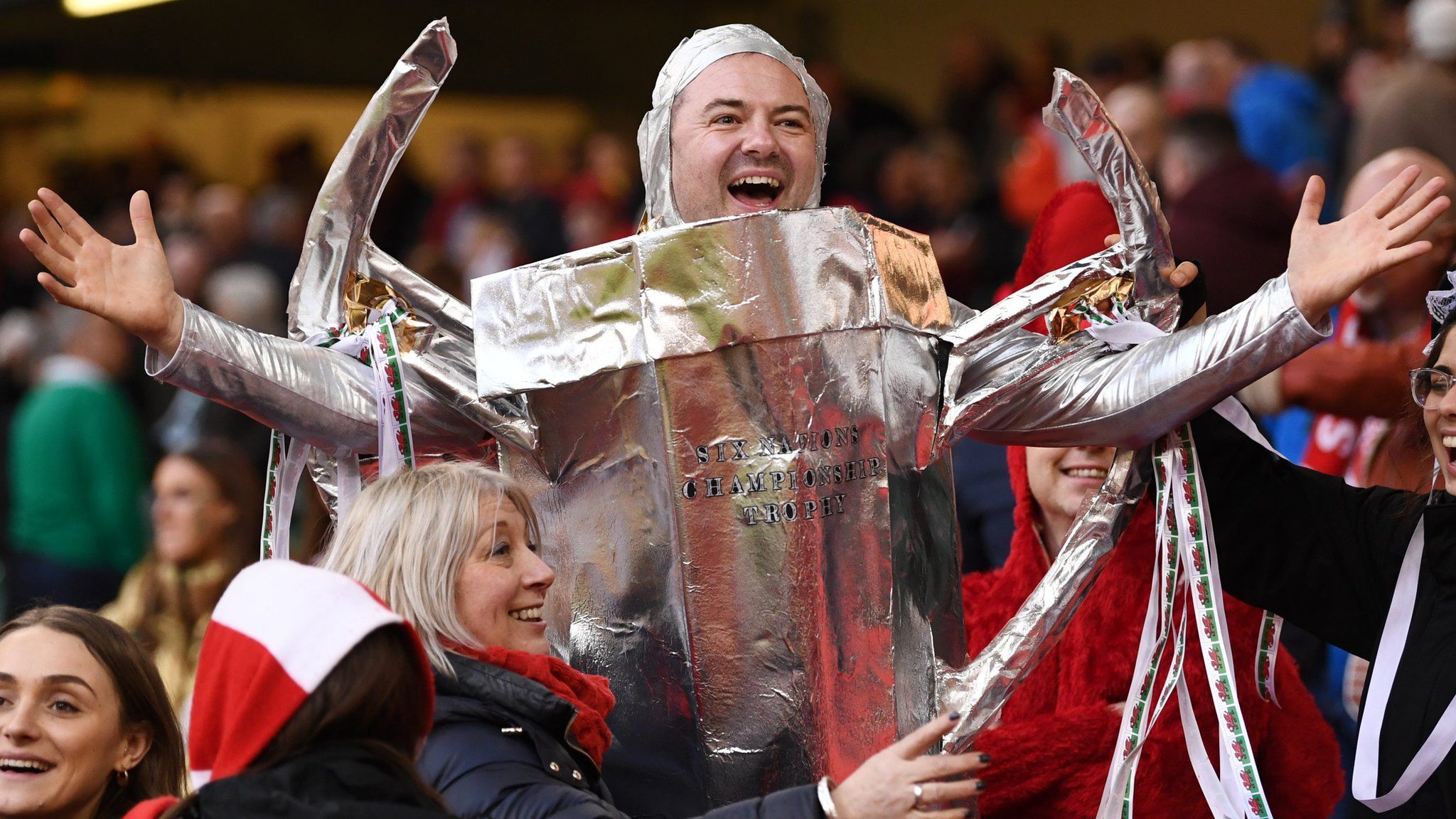 A Wales fan celebrates after Wales' Grand Slam win, dressed as the Six Nations trophy