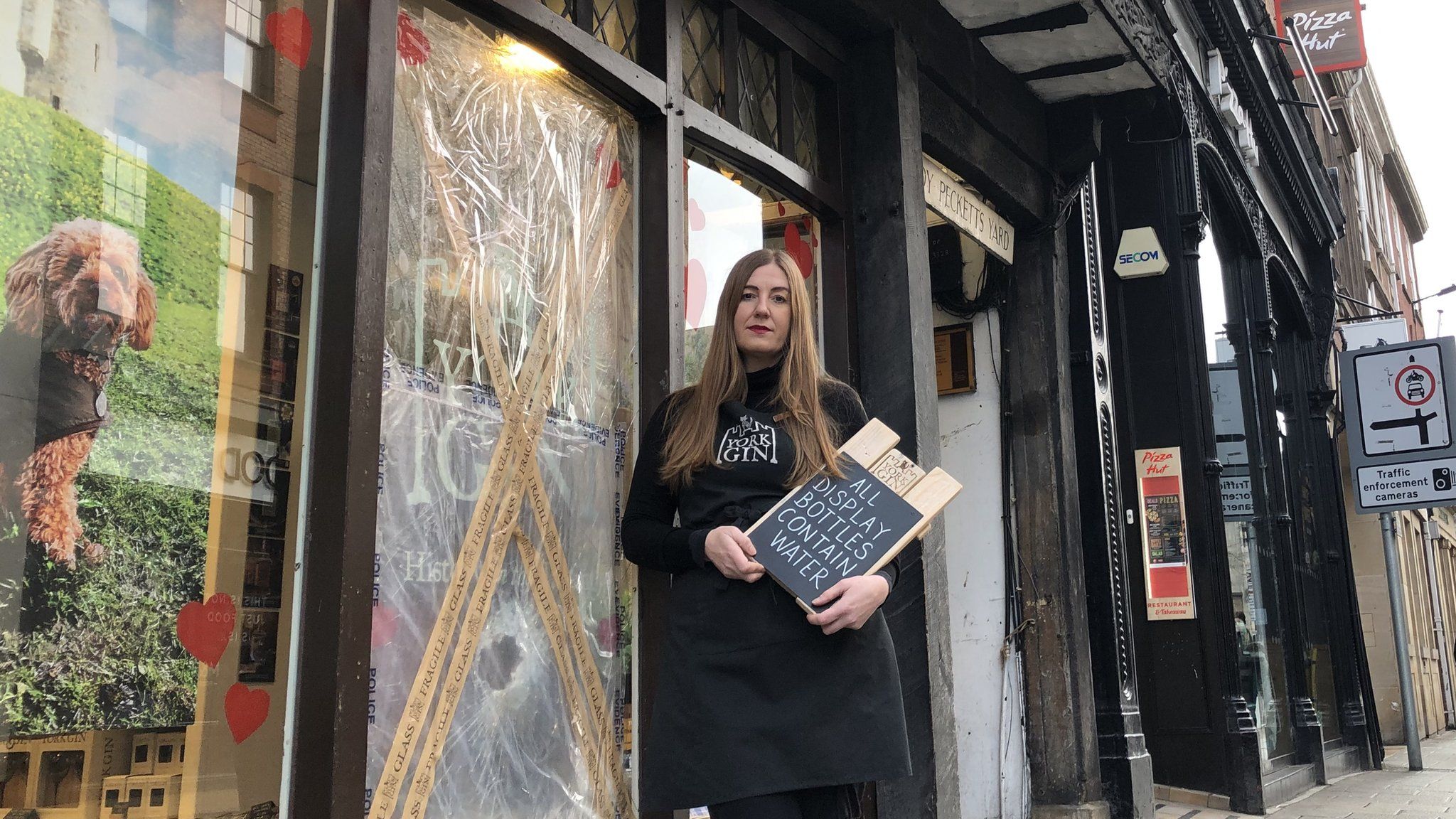 Shop worker in front of shop front