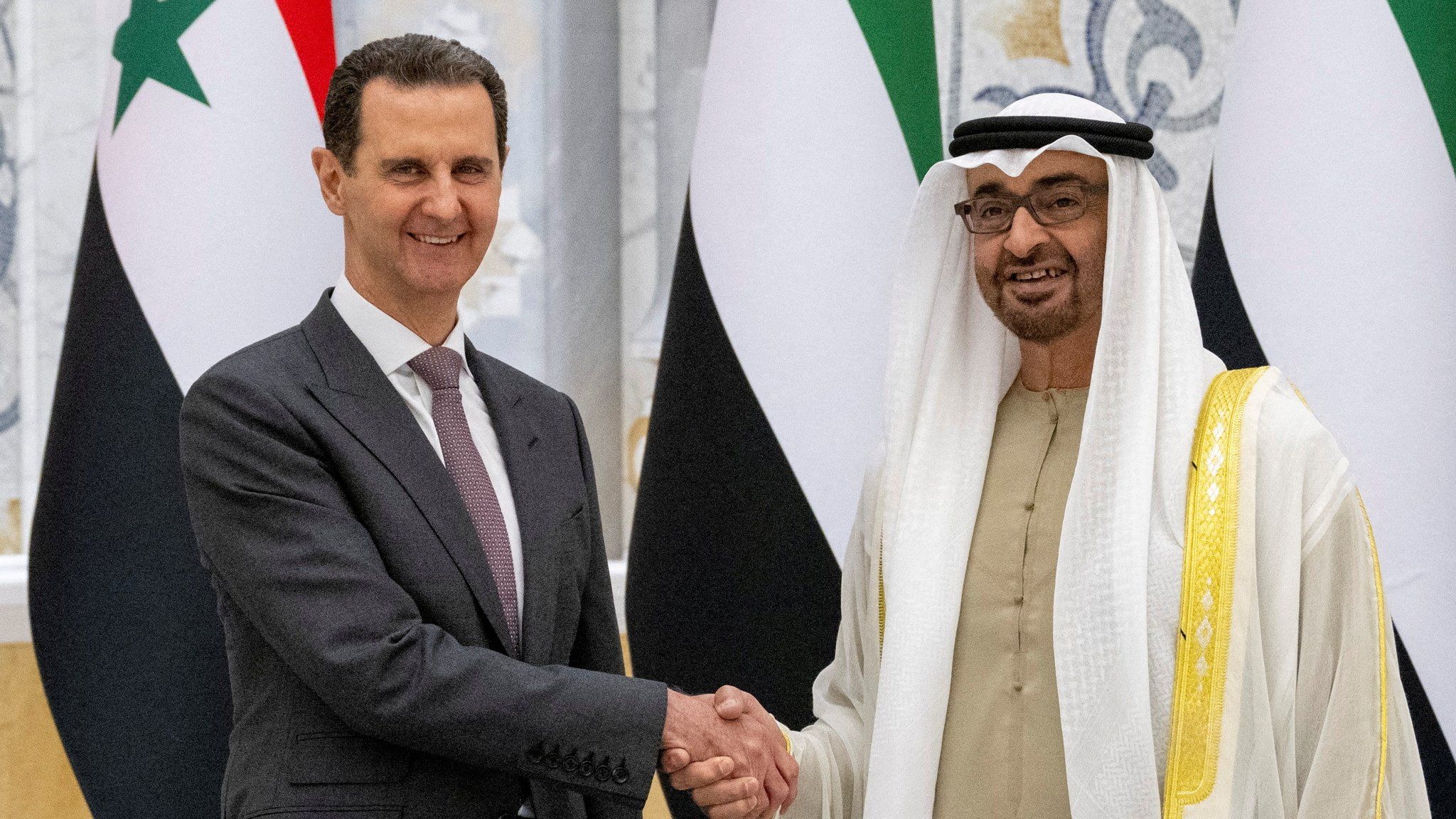 Syrian President Bashar al-Assad (L) shakes hands with UAE President Sheikh Mohammed bin Zayed Al Nahyan in Abu Dhabi (19 March 2023)