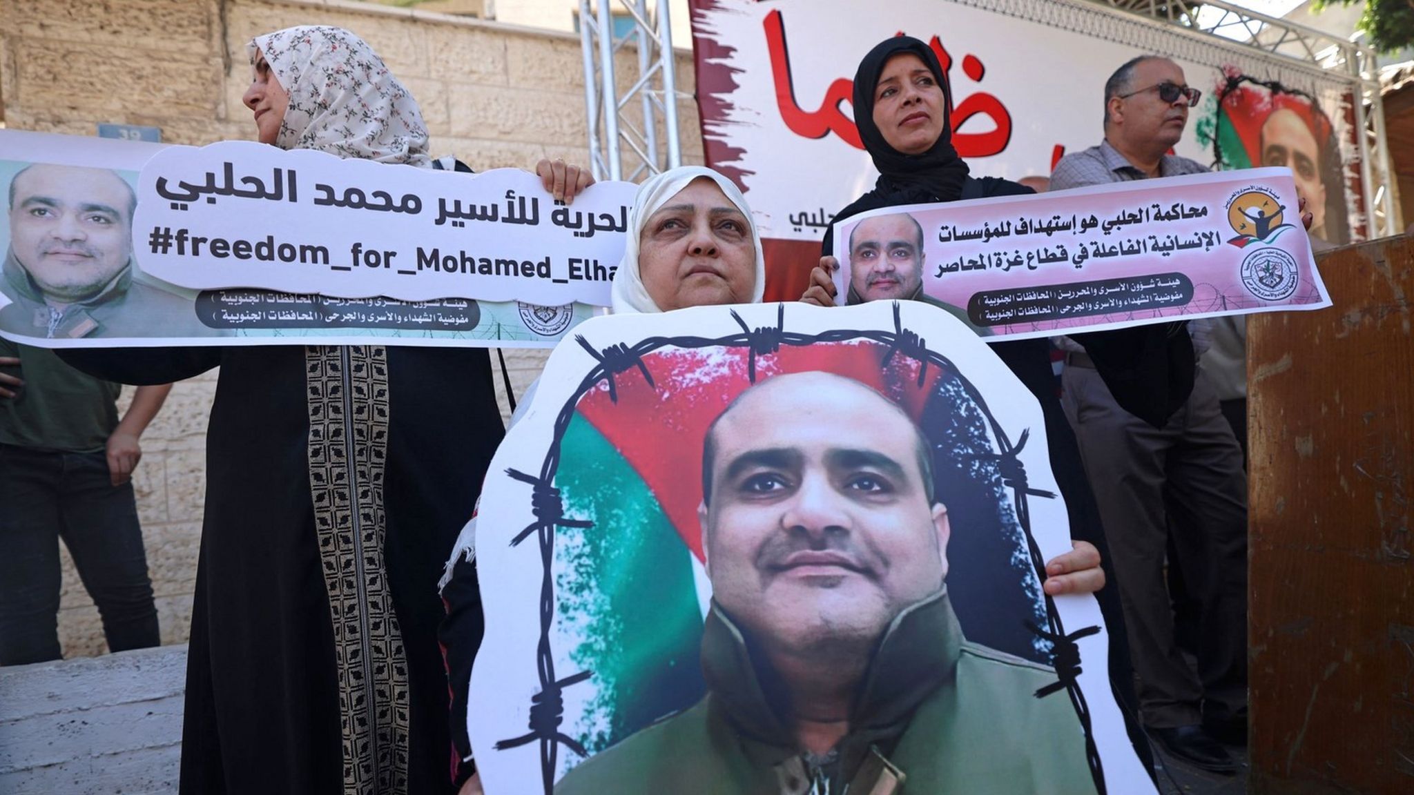 Palestinians hold posters of Mohammed Halabi, the head of the Gaza office of the charity World Vision, during a solidarity rally, in Gaza City on 15 June 2022