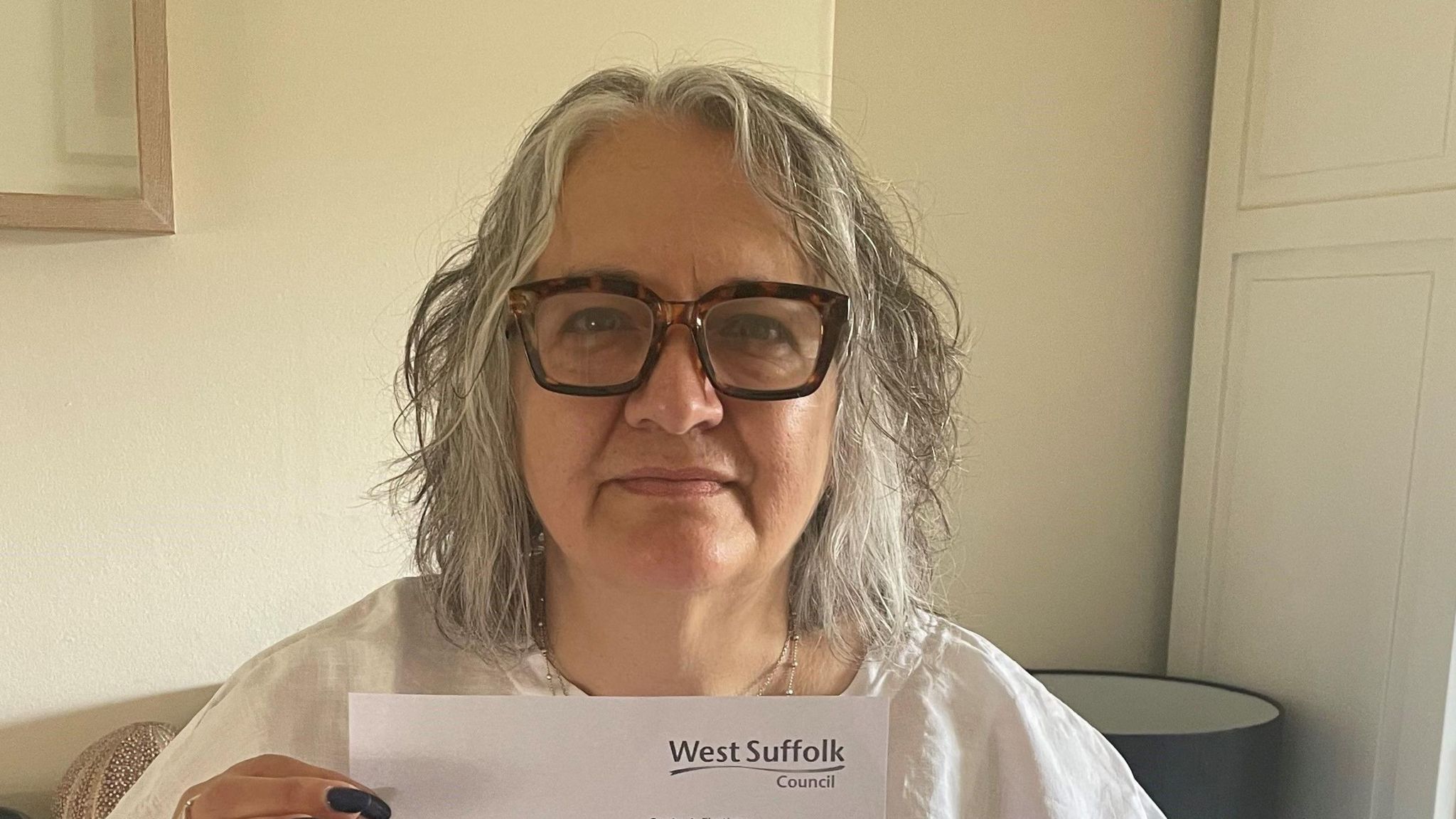 Maria Petrakis-Birkby with a letter from West Suffolk Council