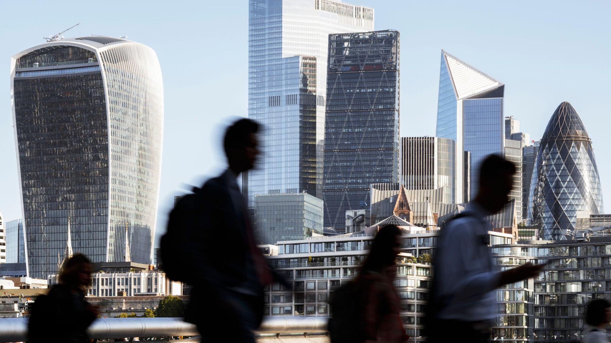 Blurred motion photo of incidental business people walking to work with view of the financial district behind