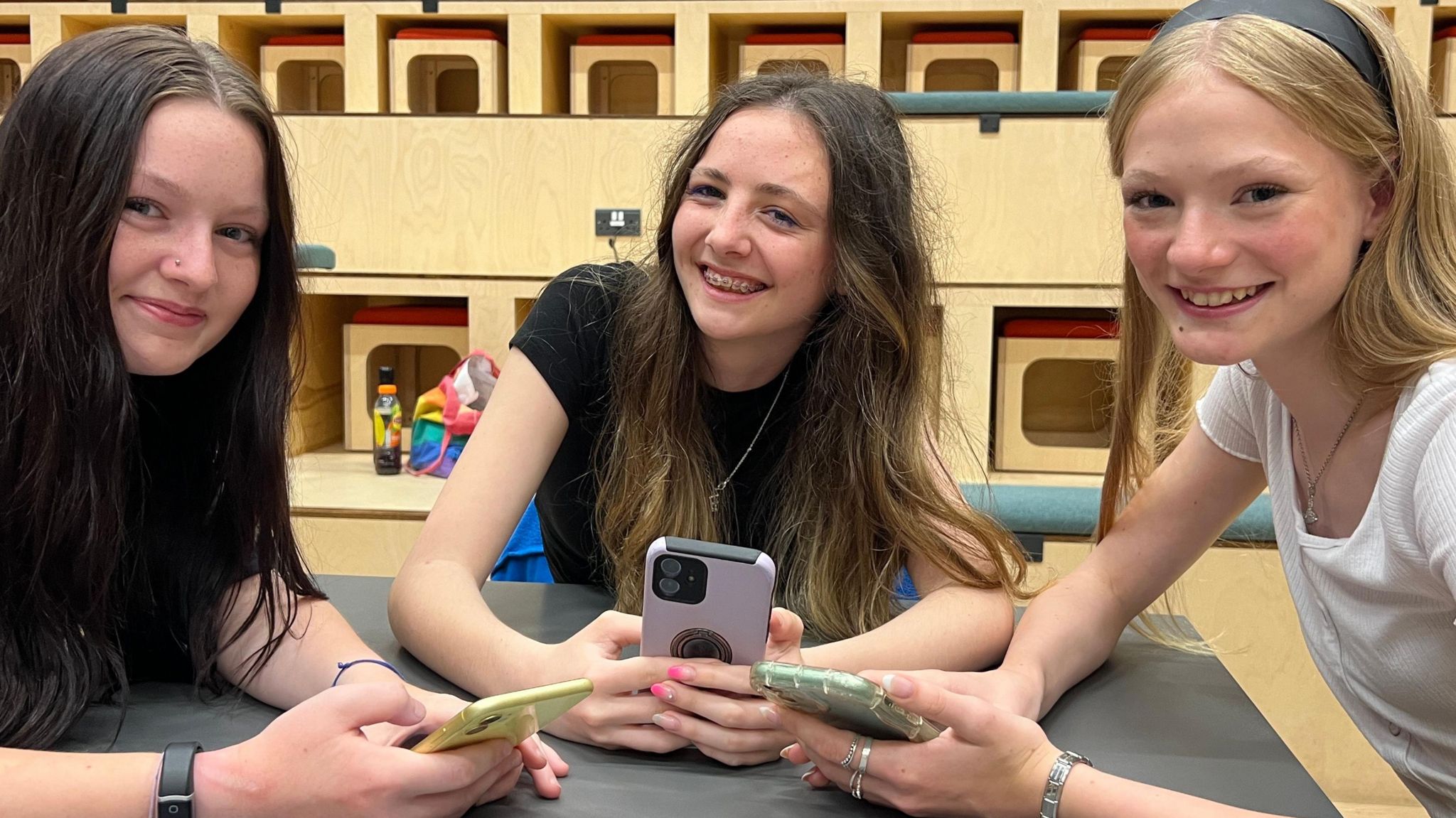 Teenagers Courtney, Ffion and Grace on their mobile phones