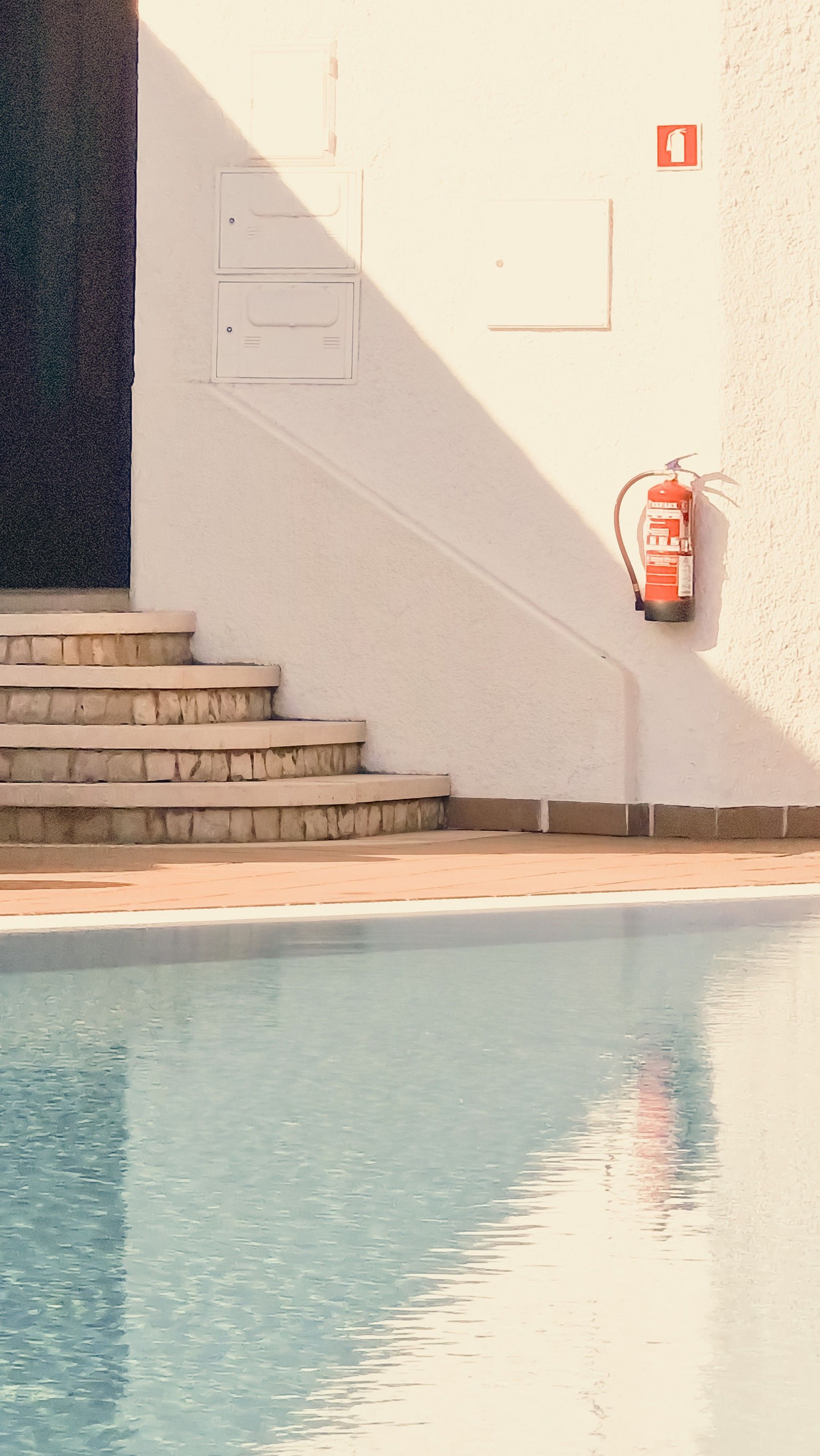 A swimming pool and steps in shadow